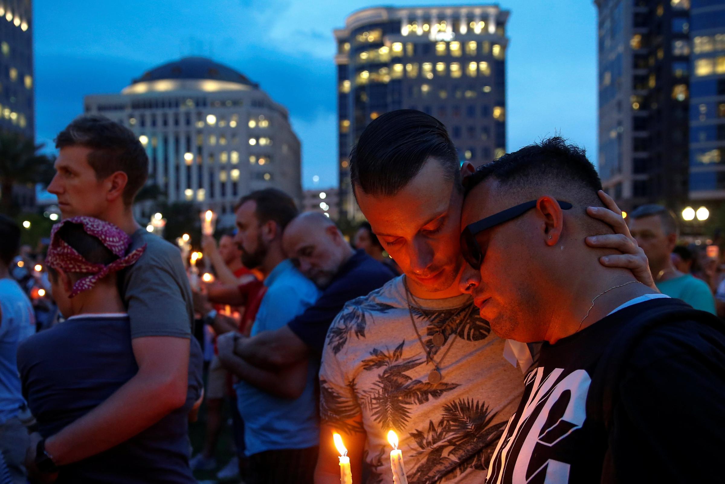 Men embrace during a candle light vigil in memory of victims one day after a mass shooting at the Pulse gay night club in Orlando on June 13, 2016.