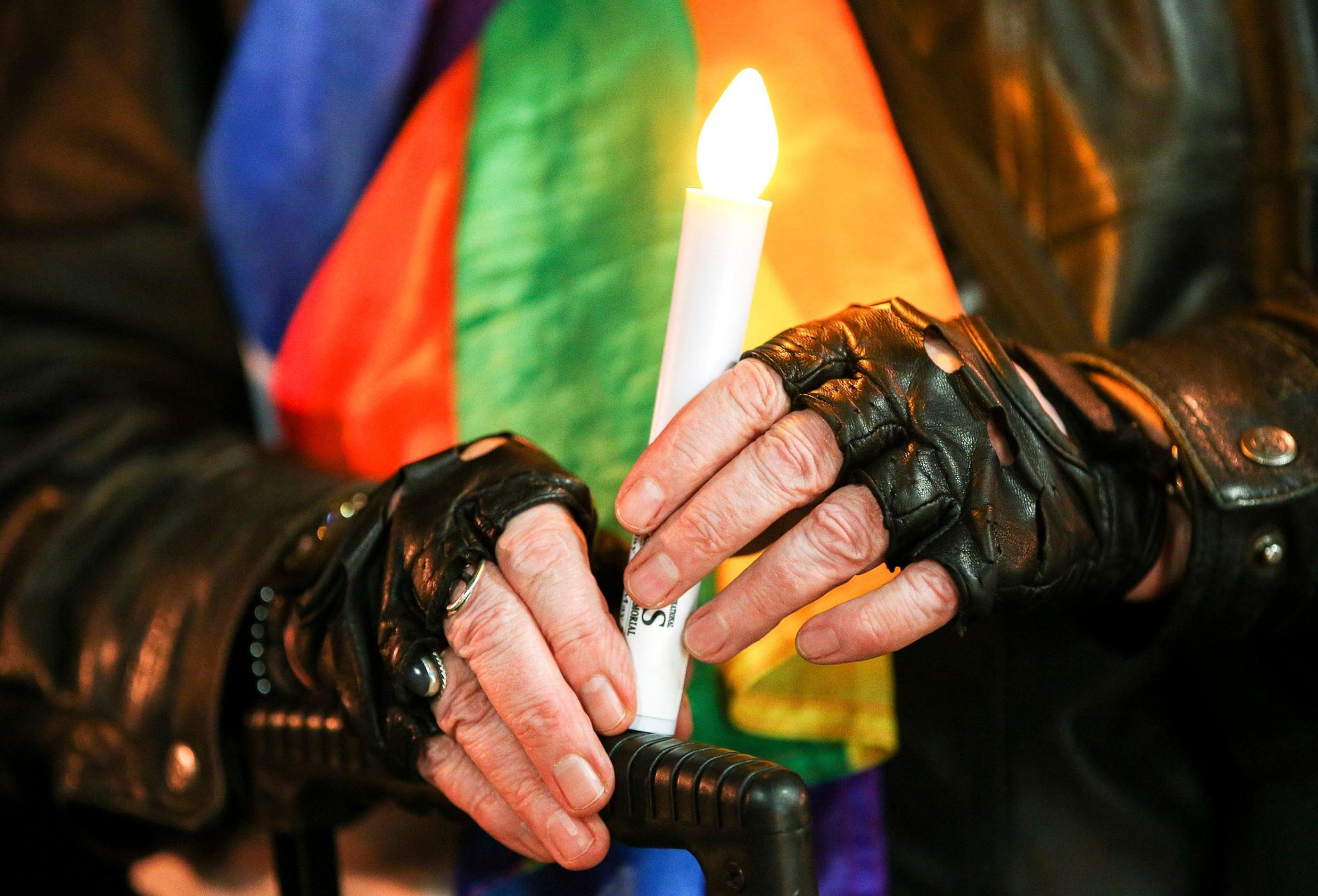 A member of the public holds a candle during a candlelight vigil for the victims of the Pulse Nightclub shooting in Orlando, at Frank Kitts Park in Wellington, June 13 2016.