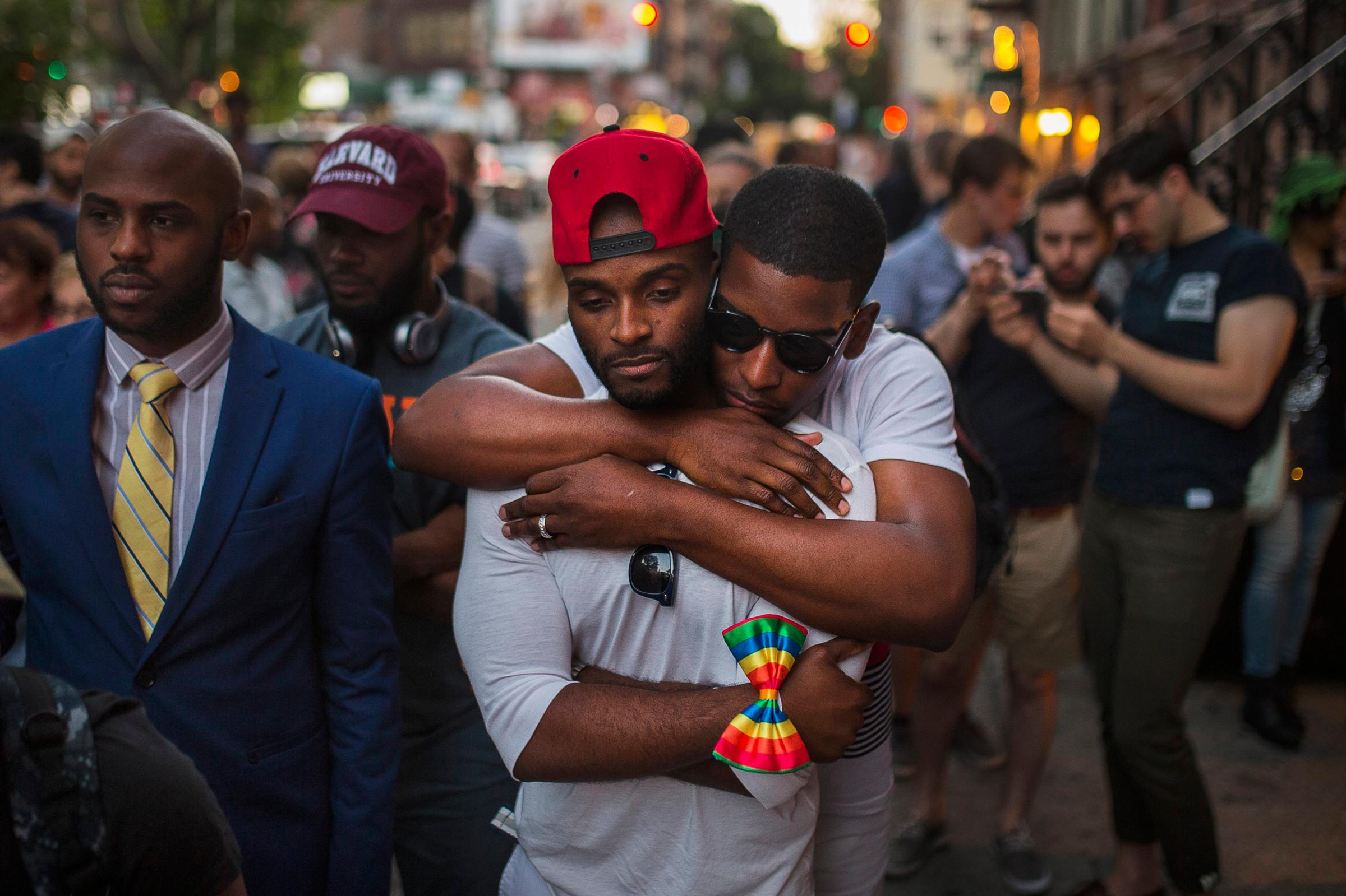 A couple embraces as people gather in front of a makeshift memorial in New York City to remember the victims of a mass shooting in Orlando, June 12, 2016.
