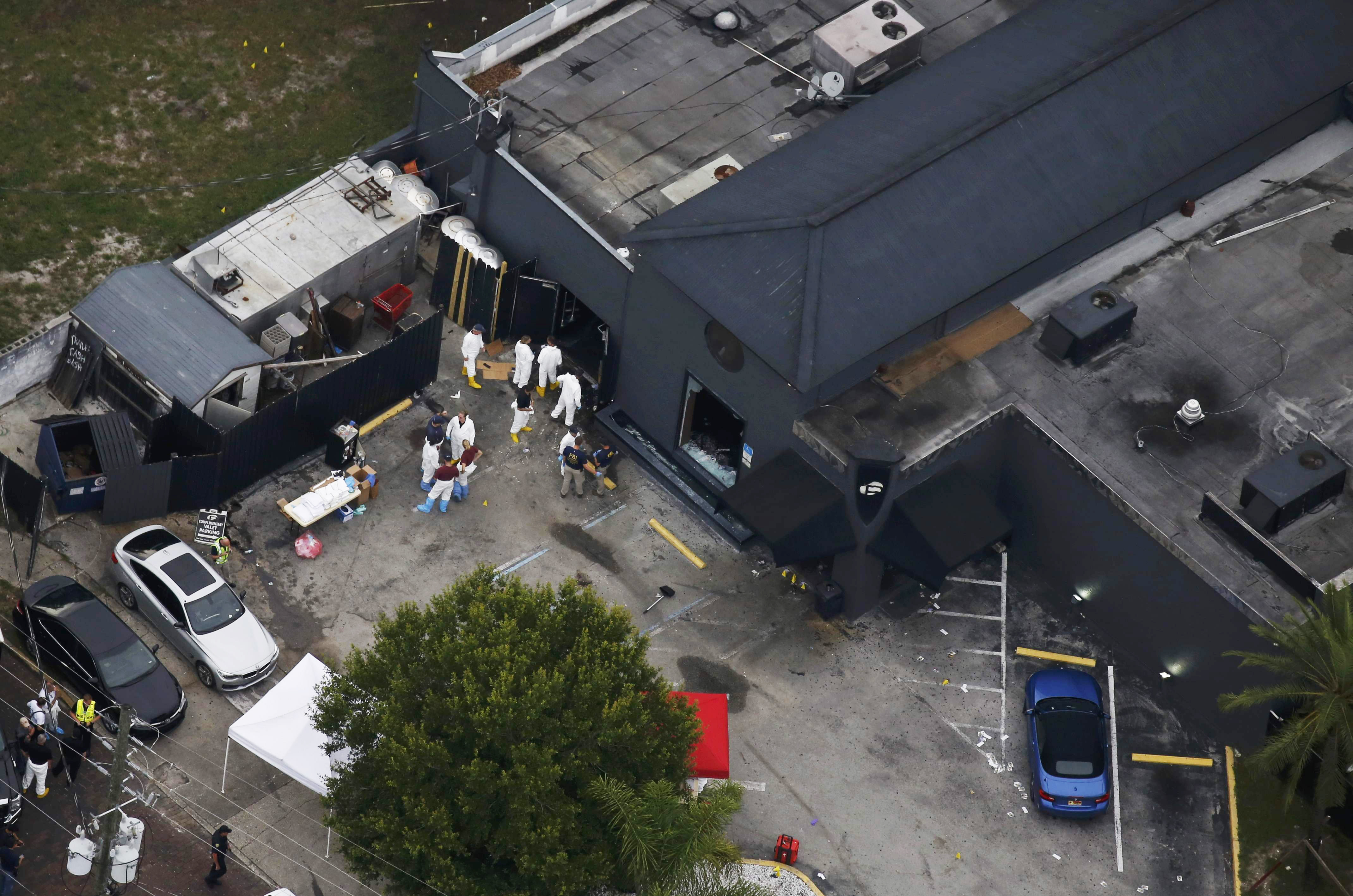 Police and forensics investigators work at the crime scene of the Pulse nightclub shooting in Orlando, Fla., on June 12, 2016.