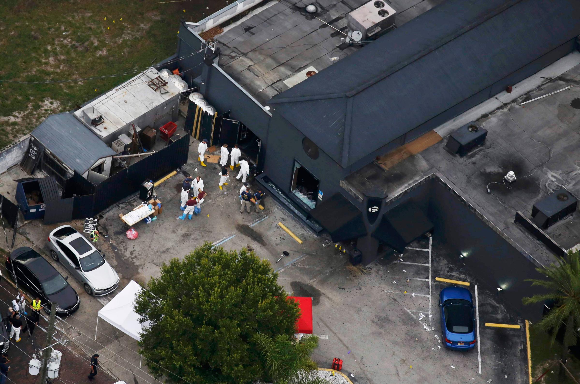 Police and forensics investigators work at the crime scene of the Pulse nightclub shooting in Orlando, Fla., on June 12, 2016.