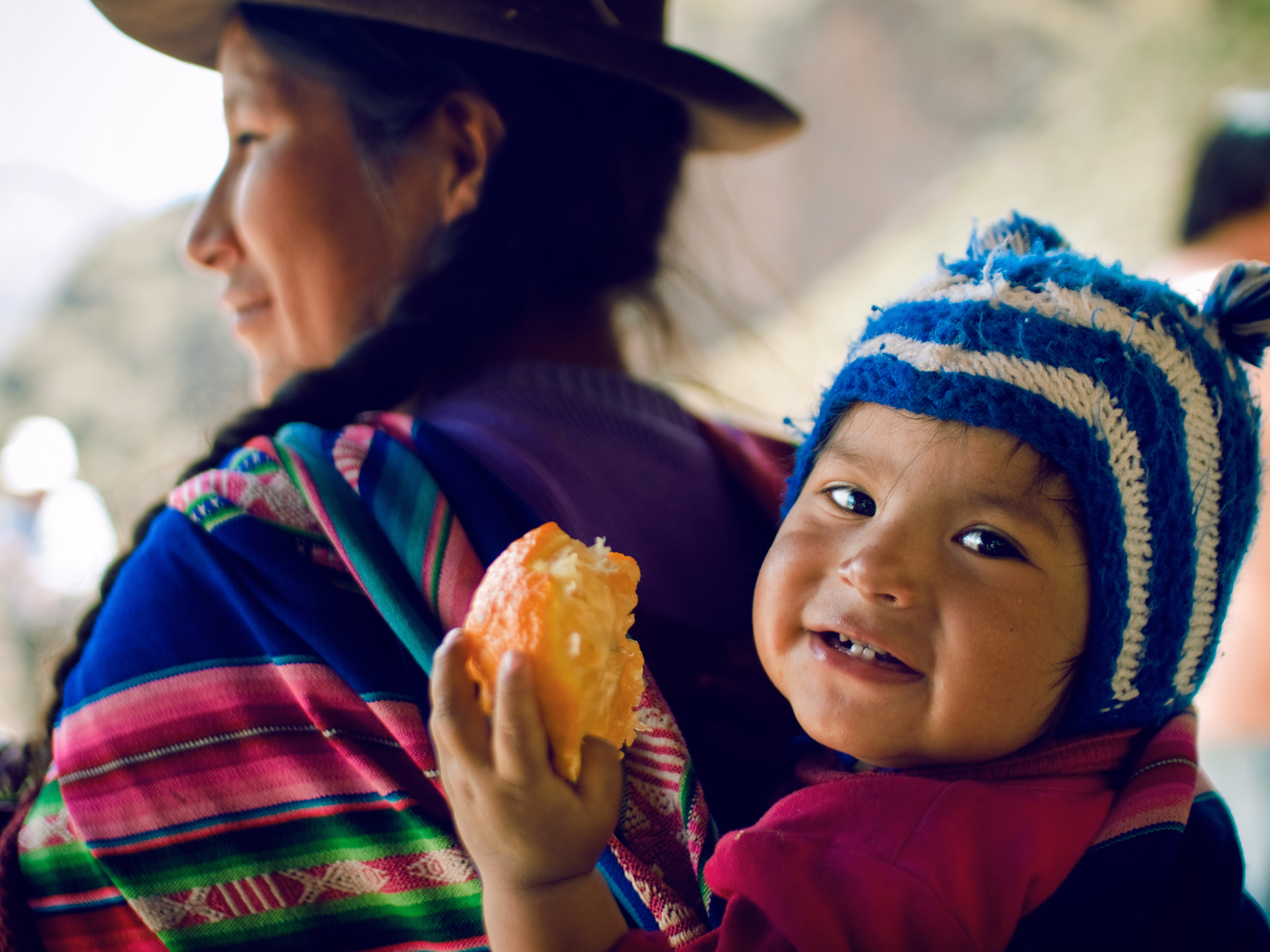 A children and her mother, wearing typical Andean wool dresses and hats, nearby the ruins of P?sac, Valle de los Incas, Peru (Thomas Cristofoletti—FlickrVision)