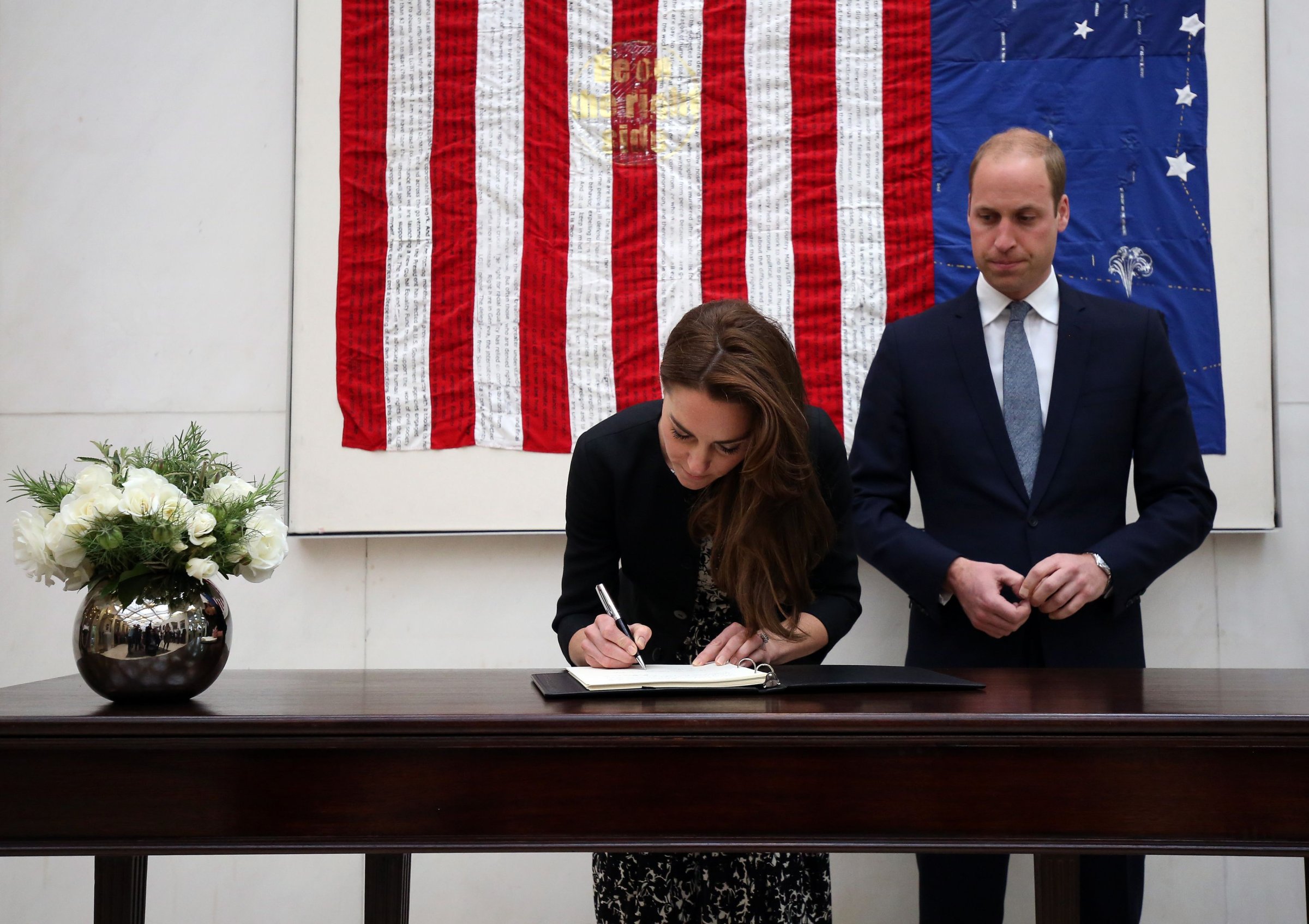 Catherine, Duchess of Cambridge signs a book of condolence for the Orlando mass shooting victims while Prince WIlliam, The Duke of Cambridge looks on at the US Embassy on June 14, 2016 in London, England.