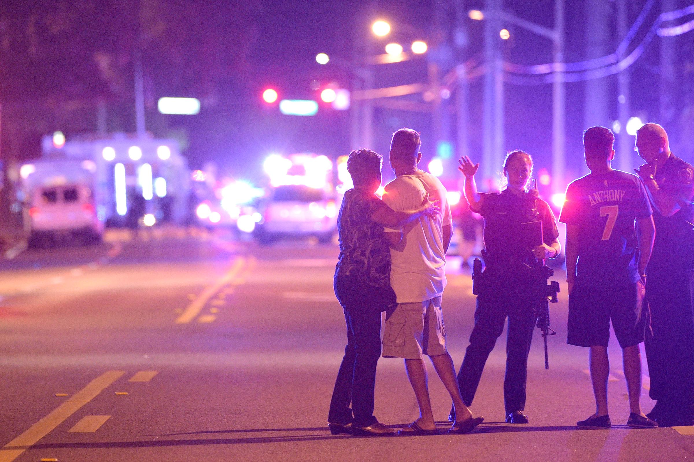 Police officers direct family members away from a shooting at Pulse nightclub in Orlando, Fla., on June 12, 2016.