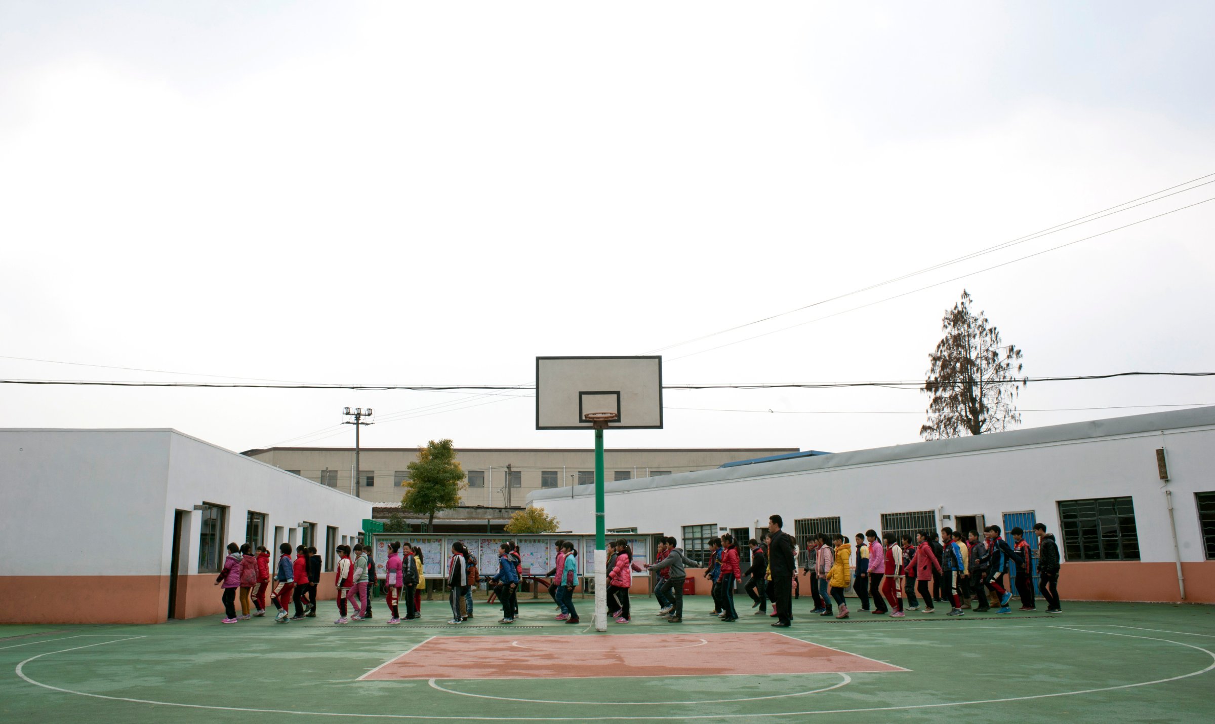 Students line up doing exercise on playground at a primary school for children of migrant workers in Shanghai