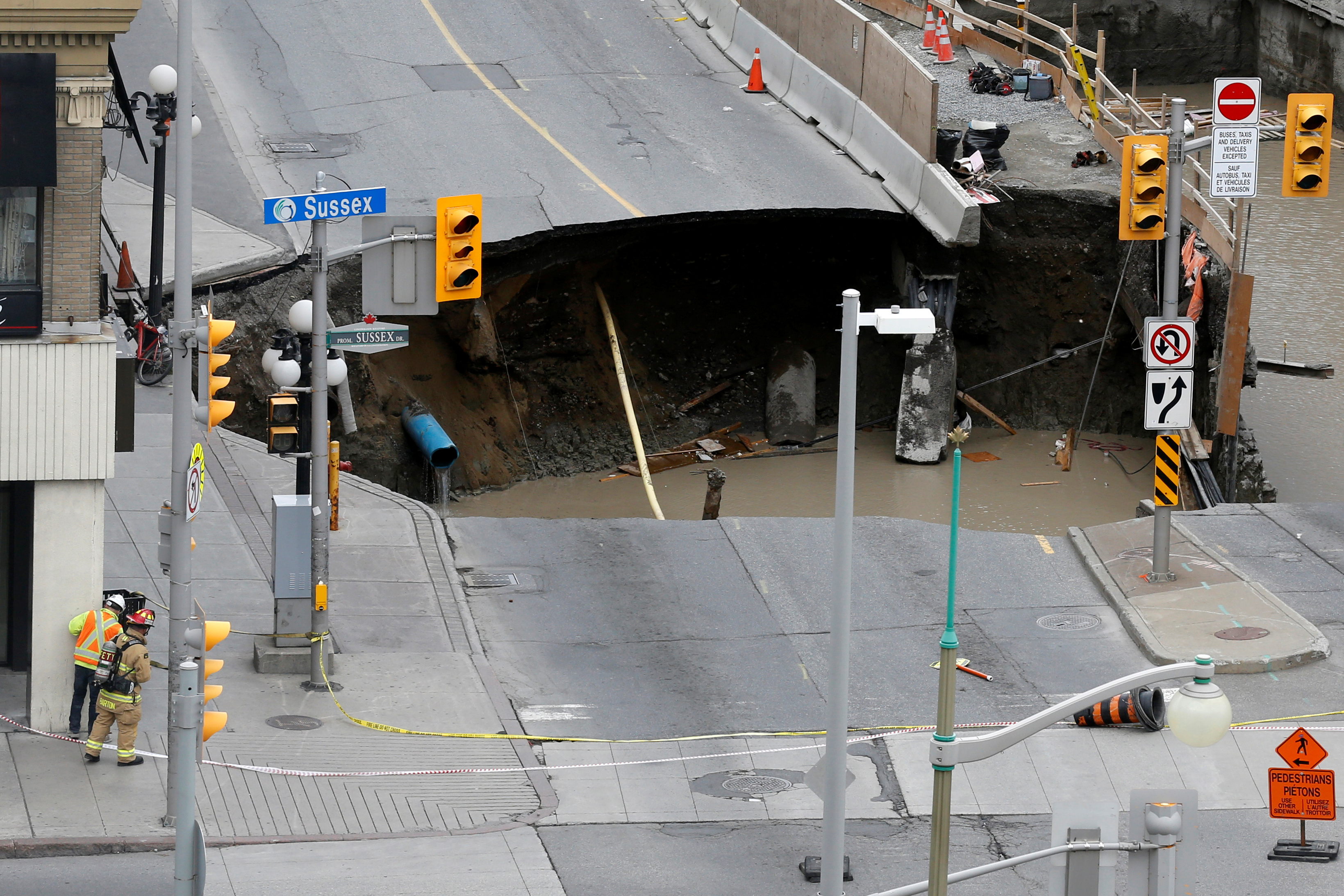 Workers look at a large sinkhole in Ottawa on June 8, 2016 (Chris Wattie—Reuters)