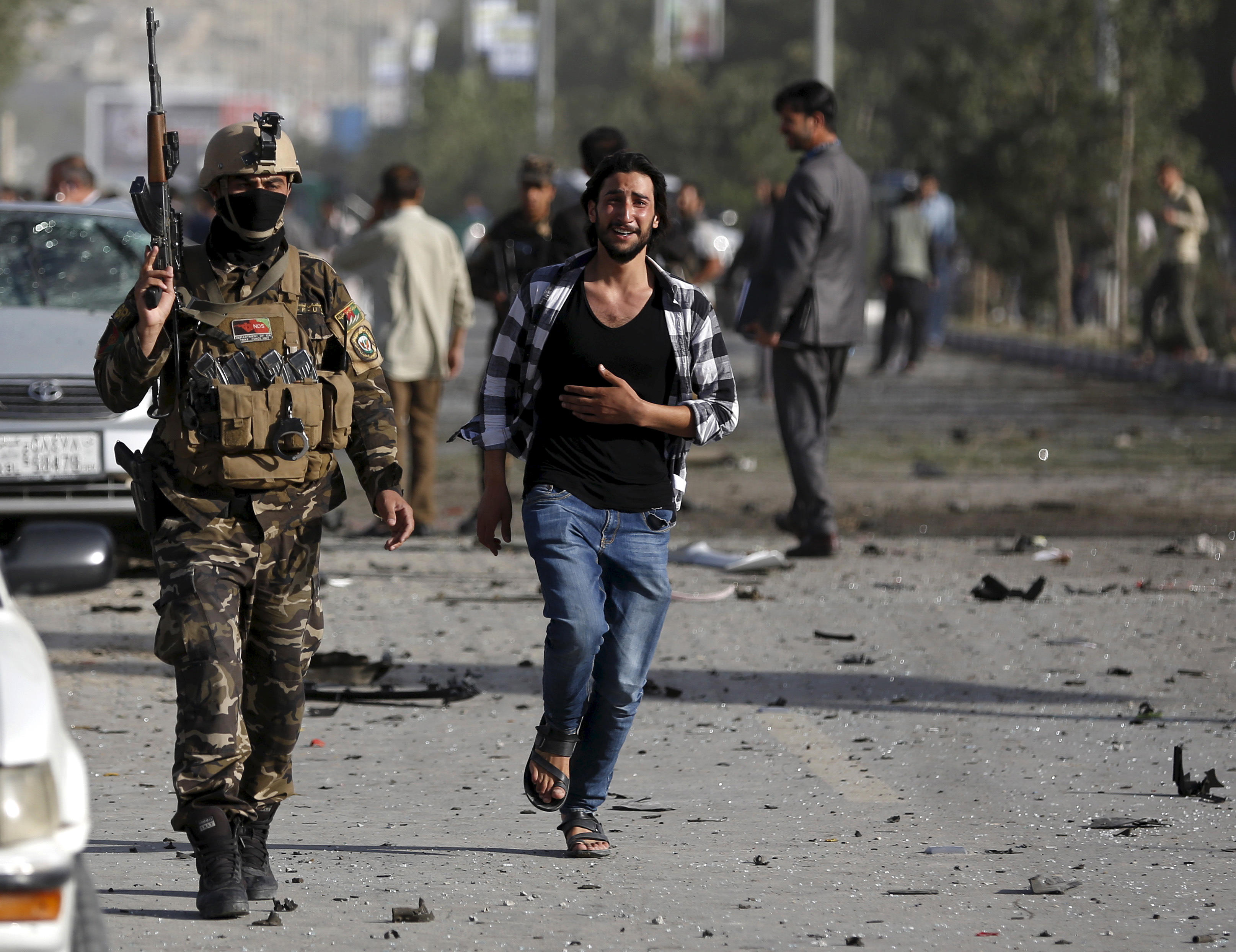 An Afghan man weeps as he runs at the site of a car bomb blast in Kabul, Afghanistan