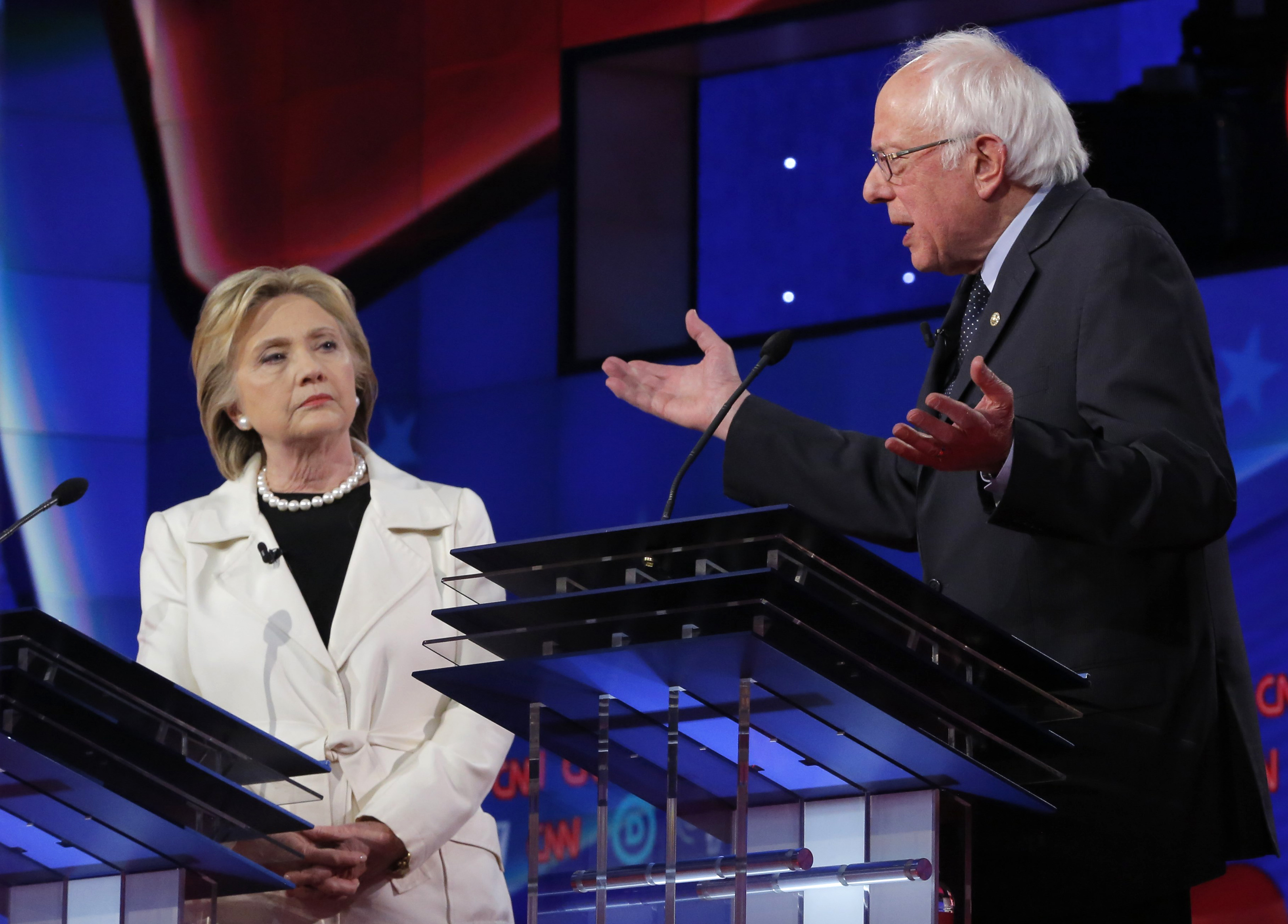 Democratic U.S. presidential candidate Clinton listens to Sanders speak during a Democratic debate in New York