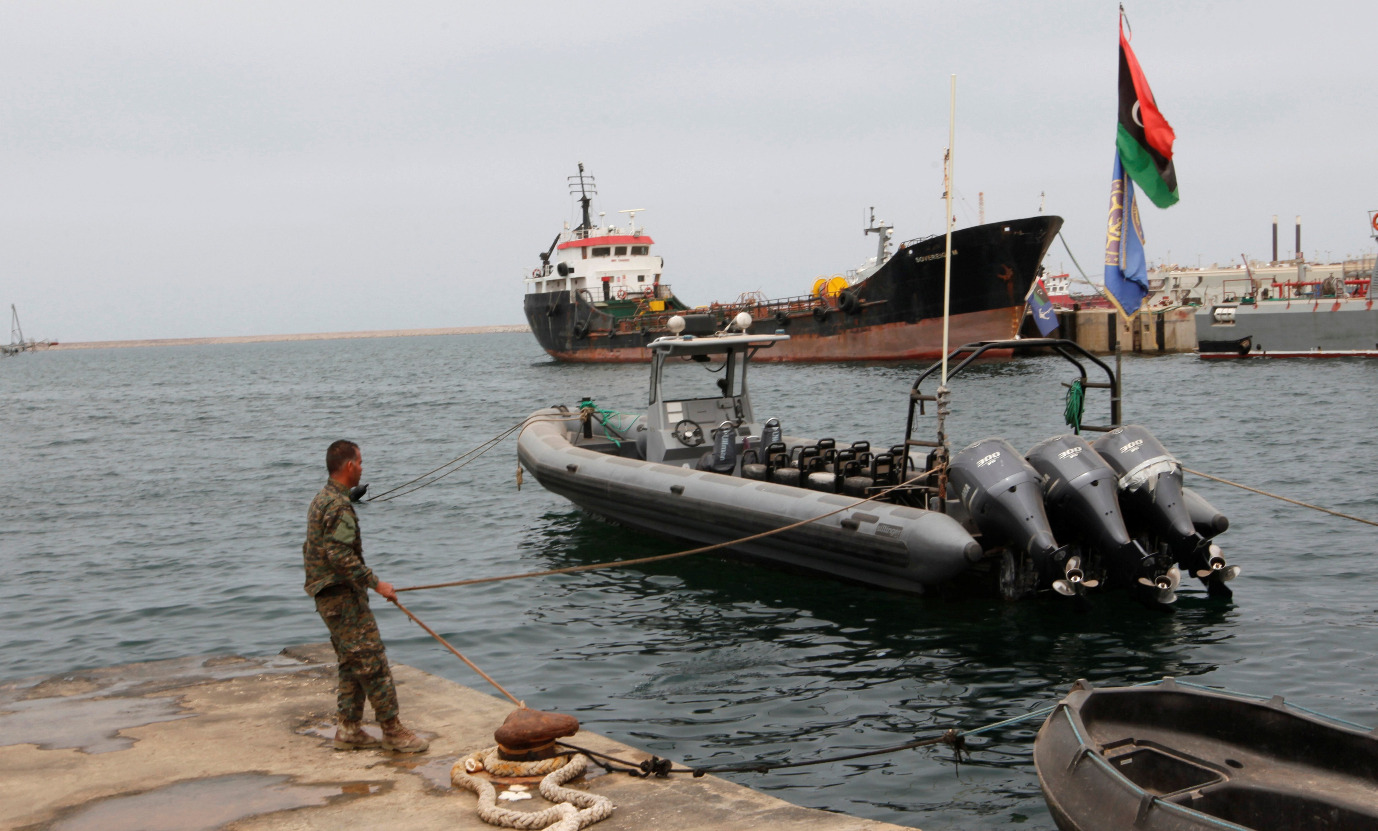 A member of the Libyan coast guard conducts a daily routine check on one of the patrol boats in Tripoli