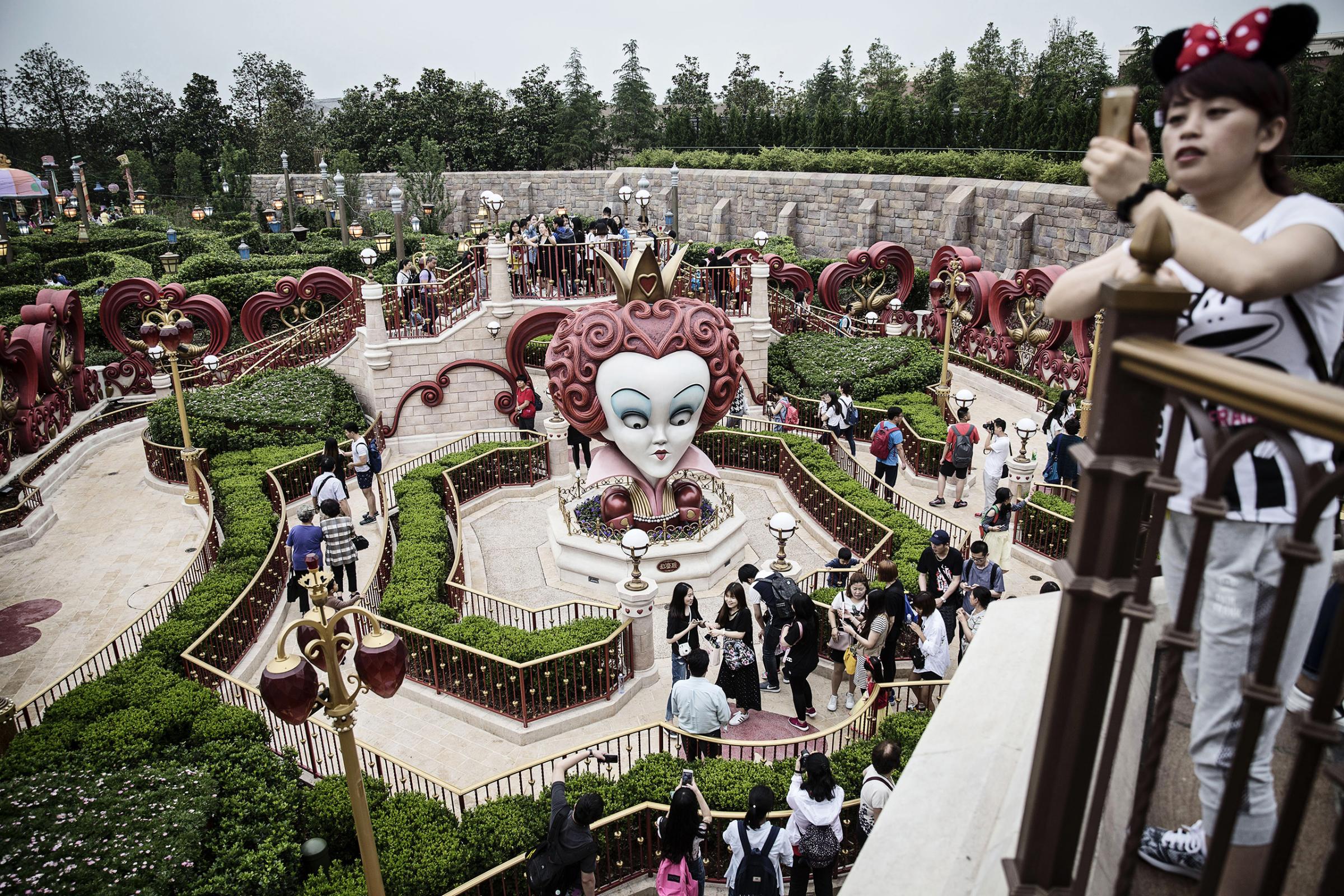 Visitors walk through the Alice in Wonderland Maze during a trial run at Shanghai Disneyland ahead of its official opening, June 8, 2016.