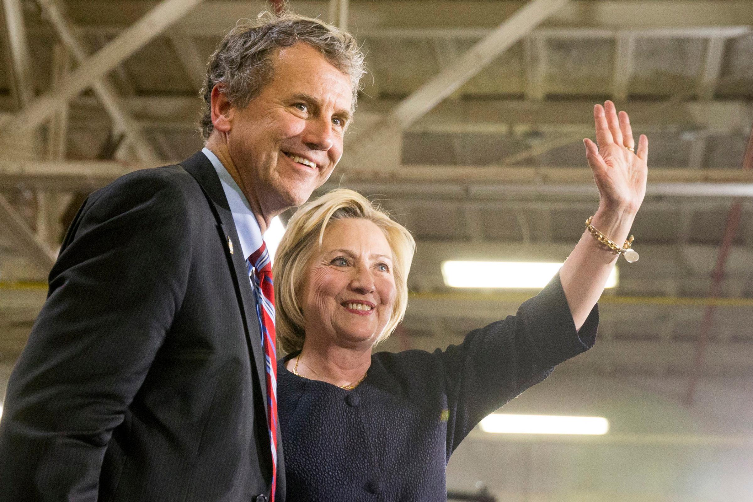 Democratic presidential candidate Hillary Clinton waves to supporters as she stands on stage with Sen. Sherrod Brown after speaking at a rally at a warehouse in Cleveland on June 13, 2016.