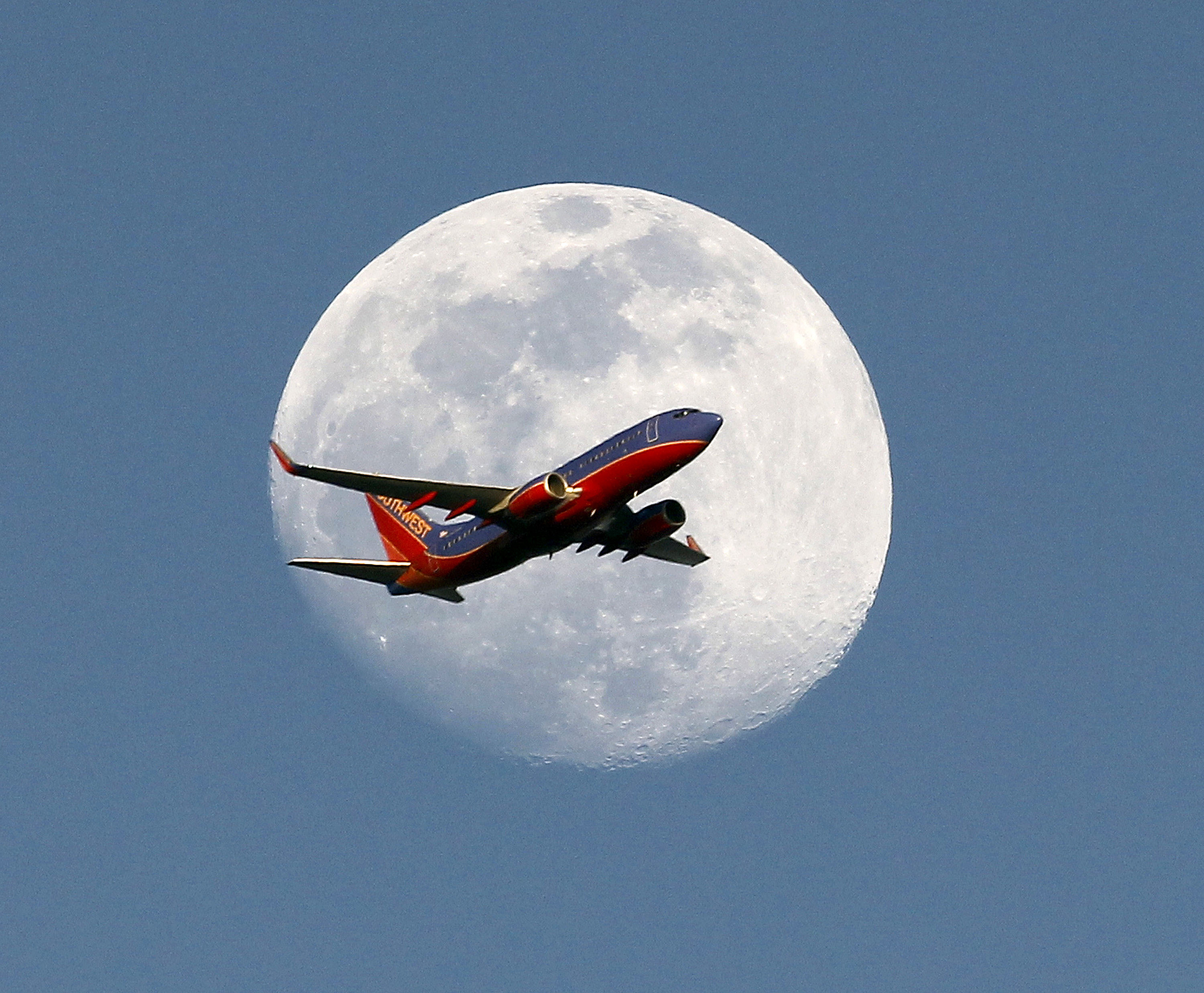 A Southwest Airlines passenger plane crosses the waxing gibbous moon in Whittier, May 30, 2015. (Nick Ut—AP)