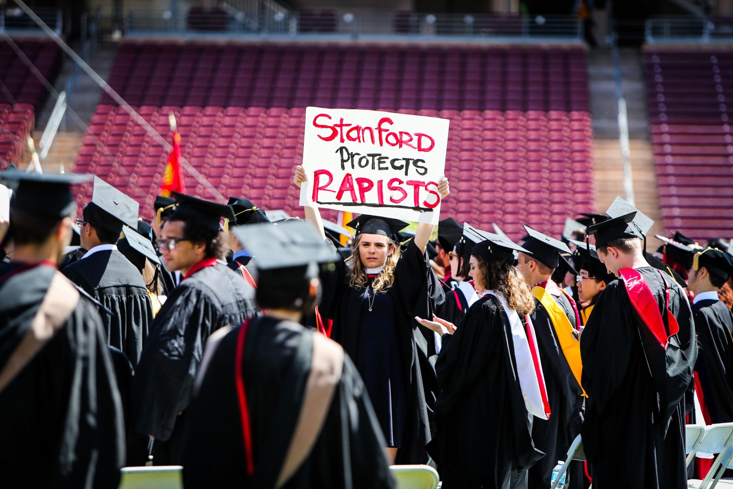 A woman carries a sign in solidarity for a Stanford rape victim during graduation at Stanford University, in Palo Alto, Calif. on June 12, 2016.