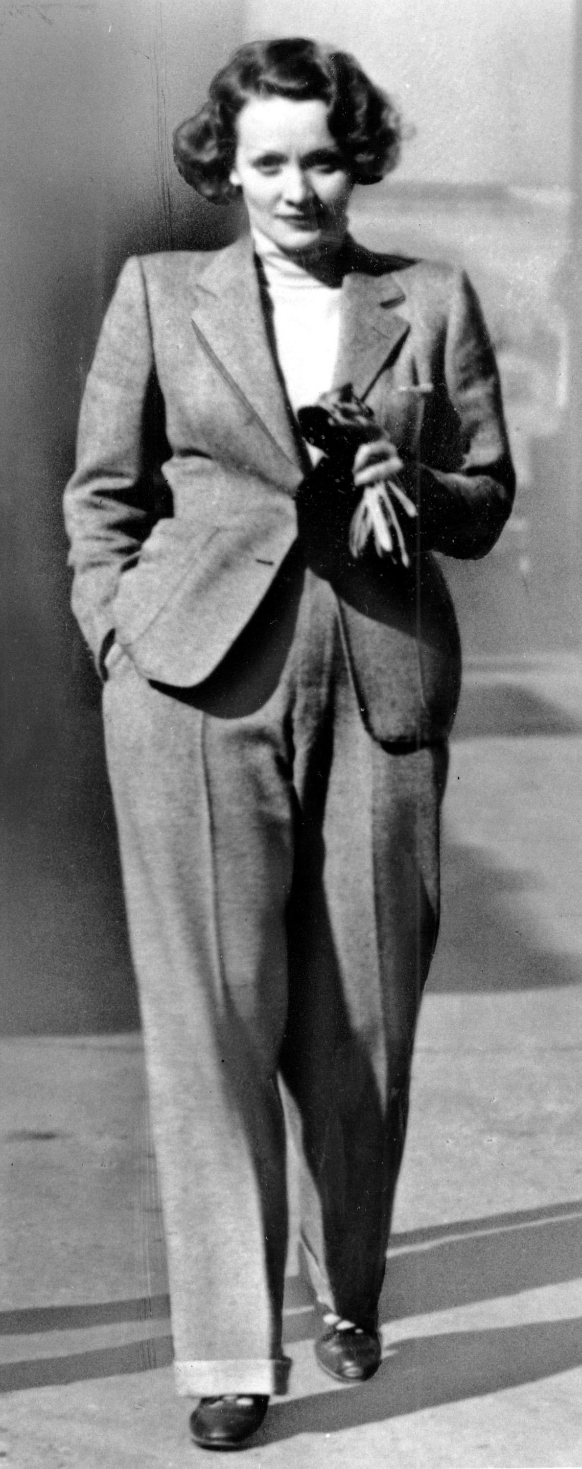 Actress Marlene Dietrich wears a trendsetting masculine style pant suit created by French couturiere Coco Chanel in 1933.