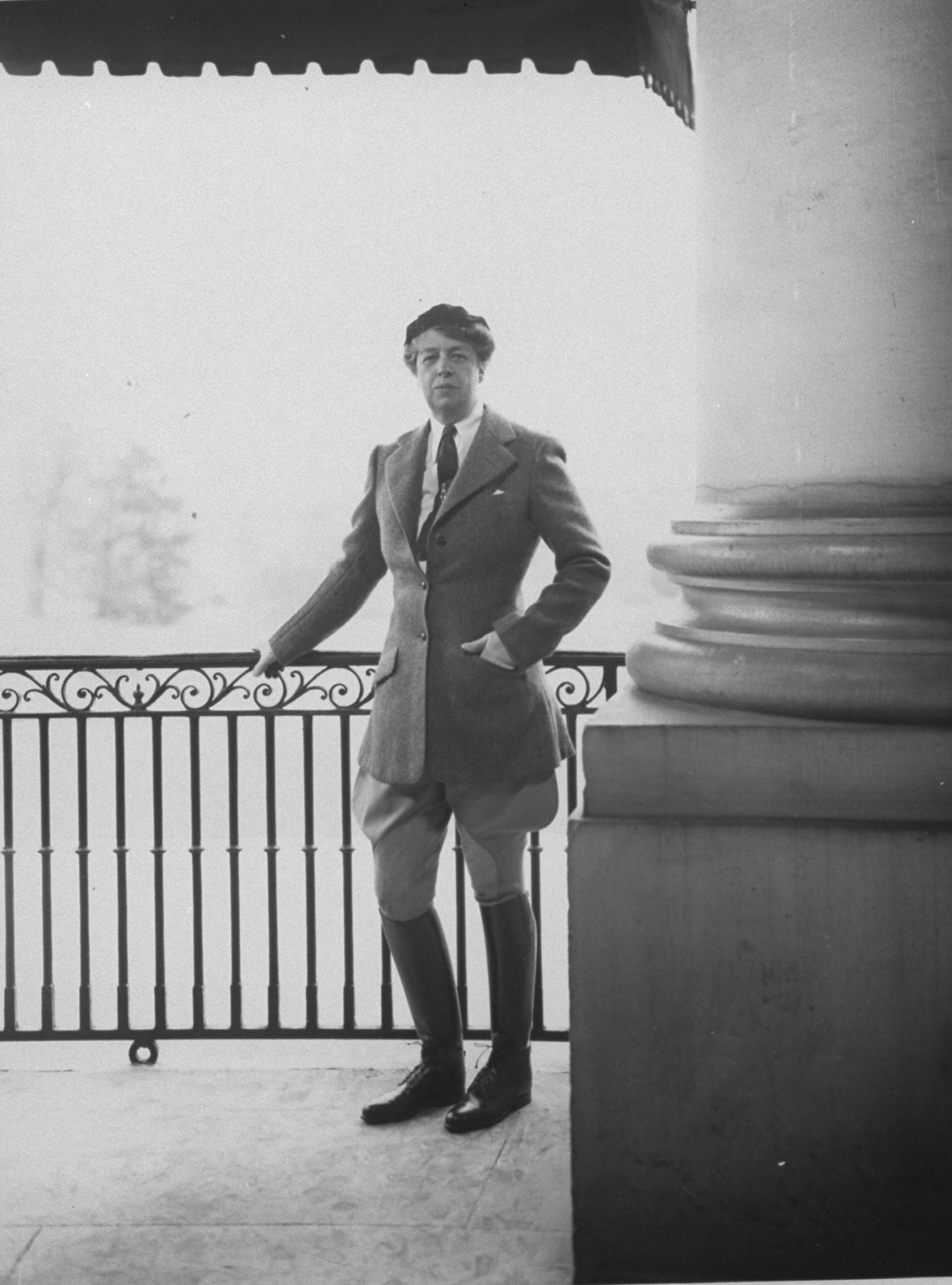 First Lady Eleanor Roosevelt wearing riding breeches and boots posing for photo on the East Portico of the White House.