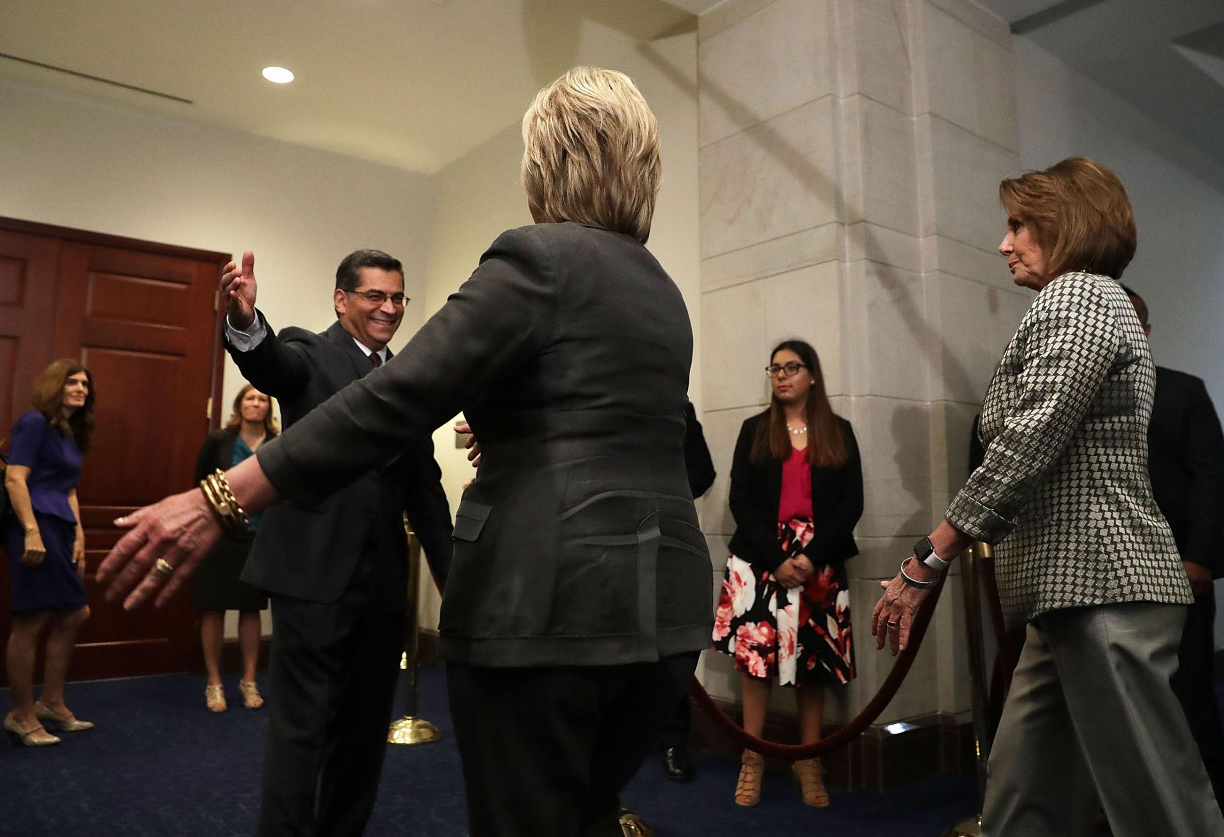 Democratic presidential candidate Hillary Clinton (C) is greeted by House Democratic Caucus Chair Xavier Becerra as she arrives to meet with House Democrats on Capitol Hill in Washington, D.C. on June 22, 2016.