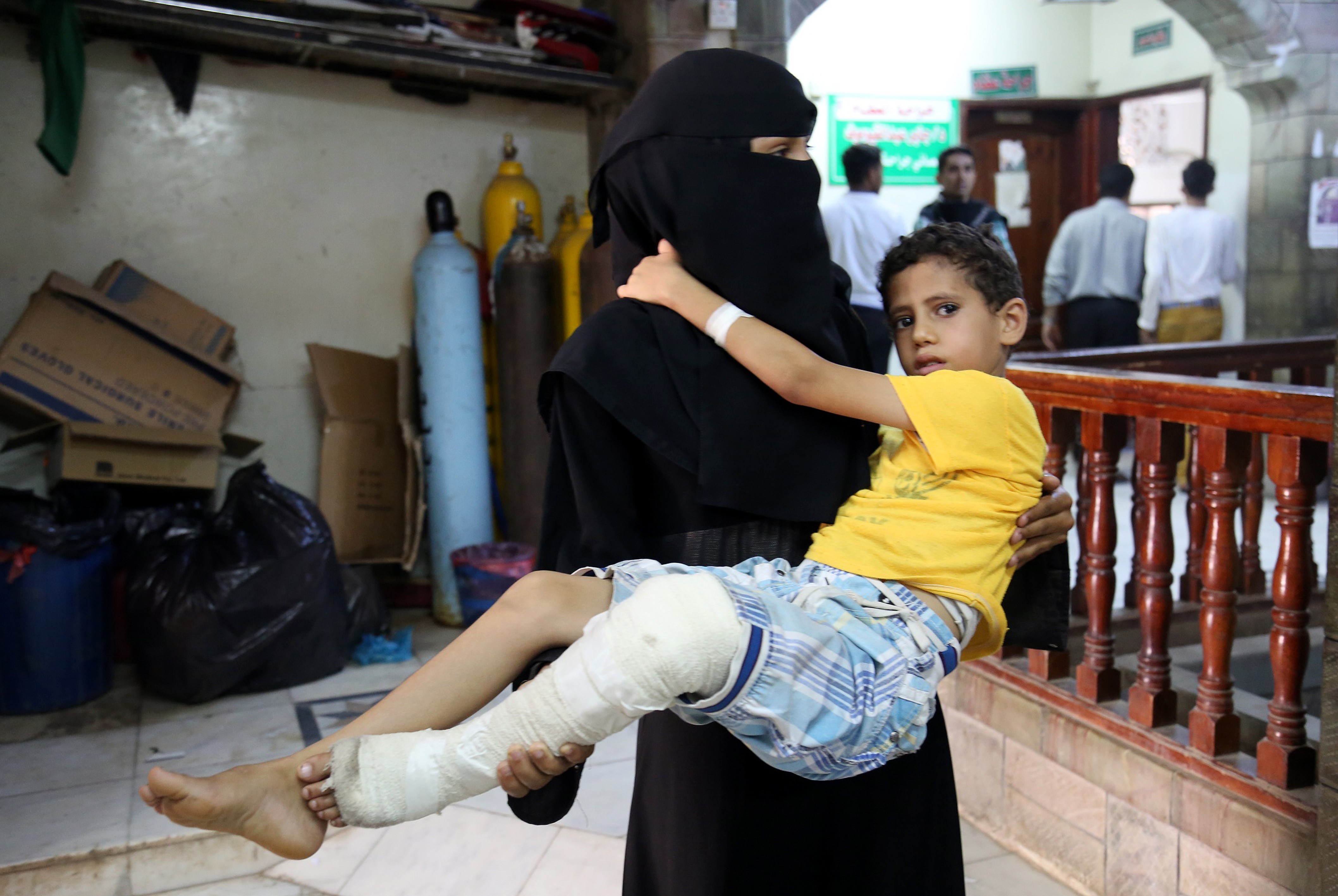 A woman carries a boy who has been injured in a Shiite Houthi attack, targeting residential areas, to es-Sevra hospital, in Taiz, Yemen, on June 4, 2016. (Anadolu Agency/Getty Images)
