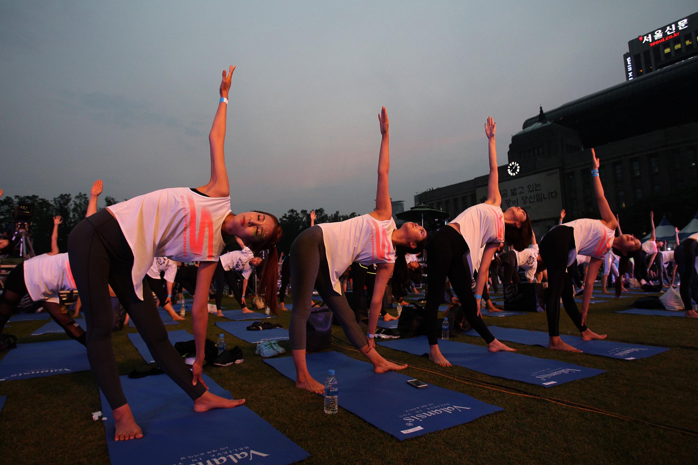 People perform yoga to mark International Day of Yoga in Seoul, South Korea, on June 21, 2016.