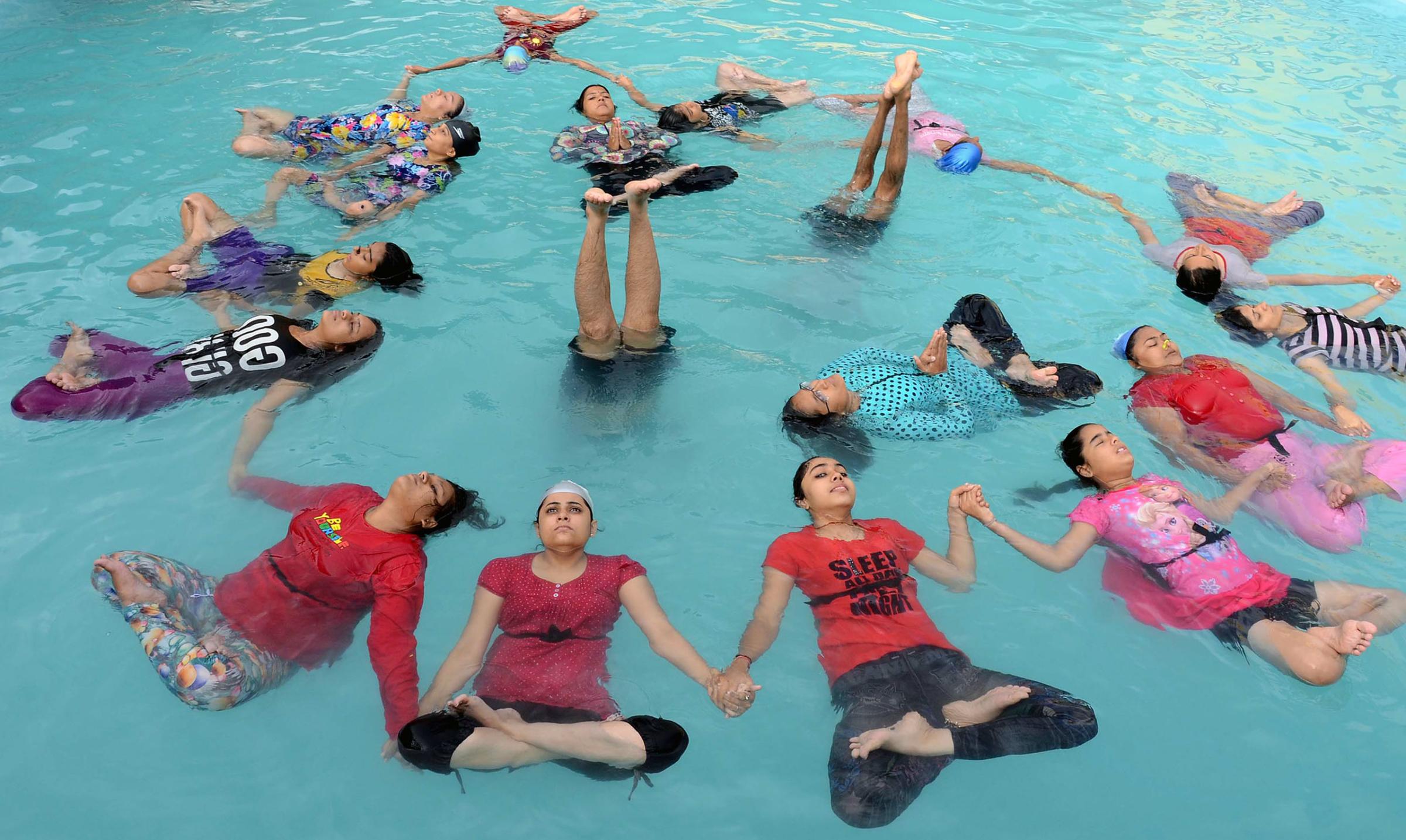 Indian yoga practitioners take part in a yoga session in a swimming pool on International Yoga Day in Jodhpur, India, on June 21, 2016.