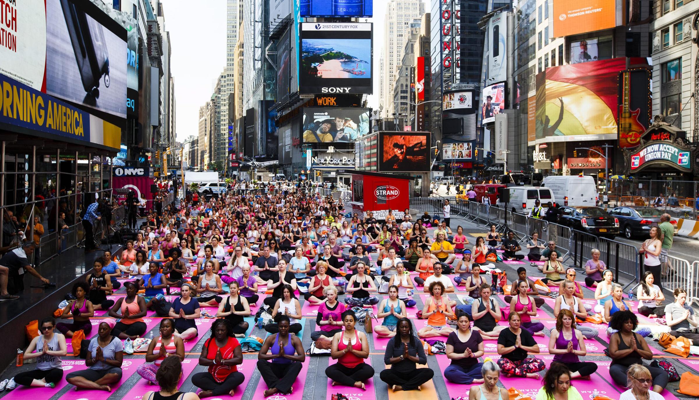 People participate in a group yoga class in Times Square as part of the 14th annual 'Solstice in Times Square: Mind Over Madness Yoga' to mark the summer solstice in New York, New York, June 20, 2016.