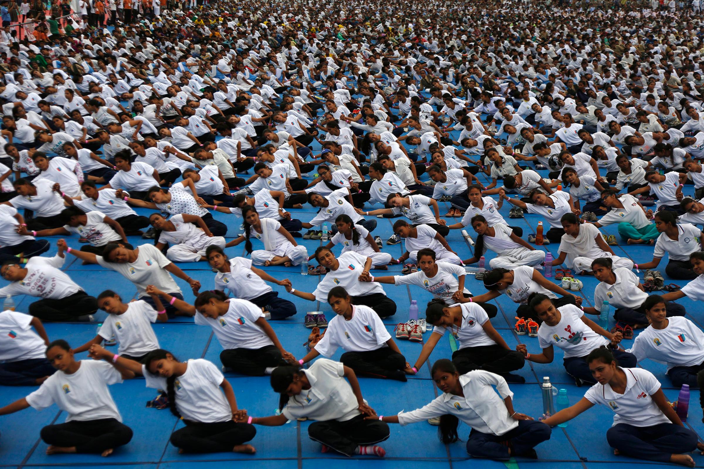 Indians holds hands as they attempt to create a record for the longest human yoga chain with more than 8000 participants at an event to celebrate International Yoga Day in Ahmadabad, India, June 21, 2016.
