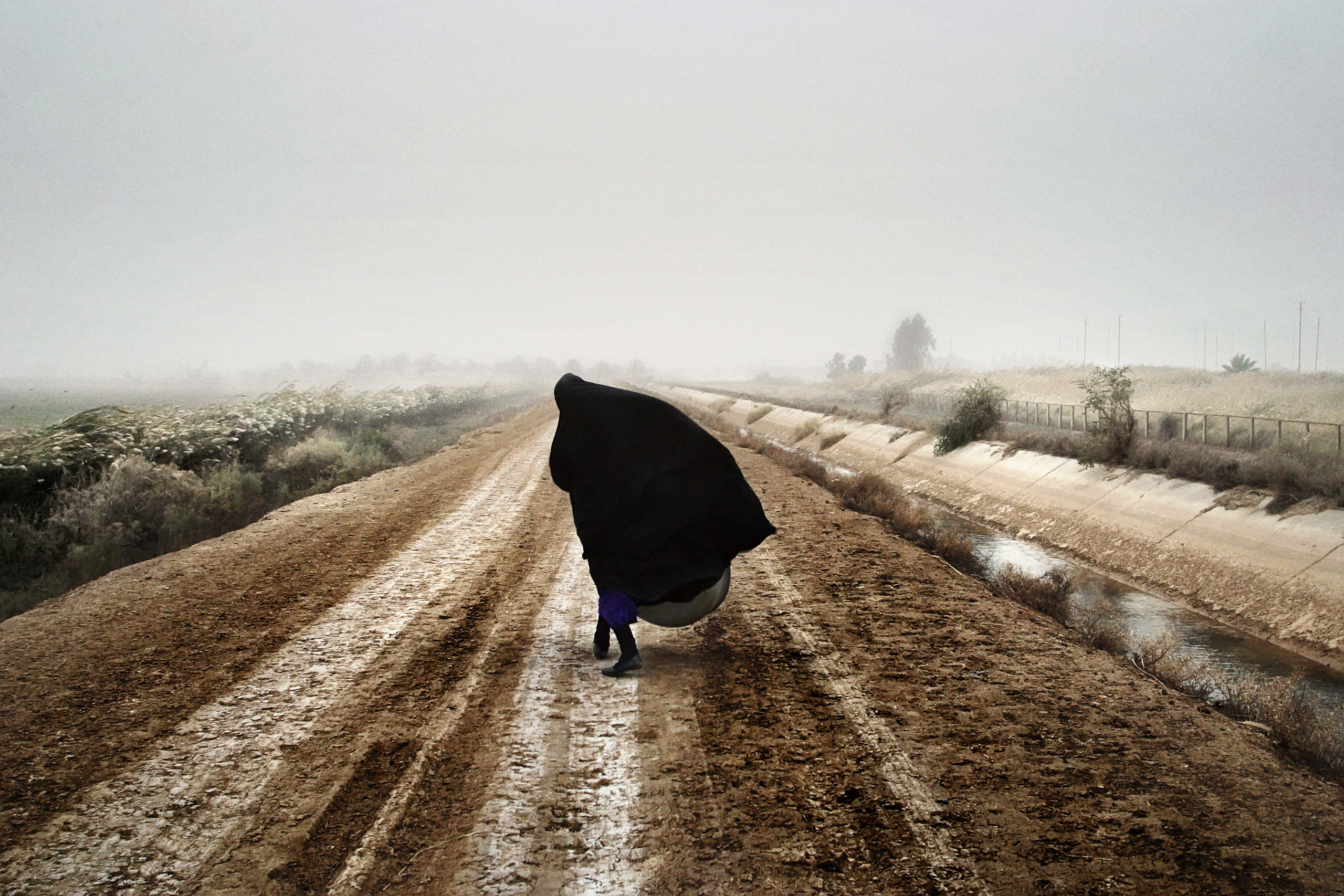 An Iraqi woman walks on a road south of Baghdad, Dec. 20, 2002, prior to the U.S. invasion in March 2003.