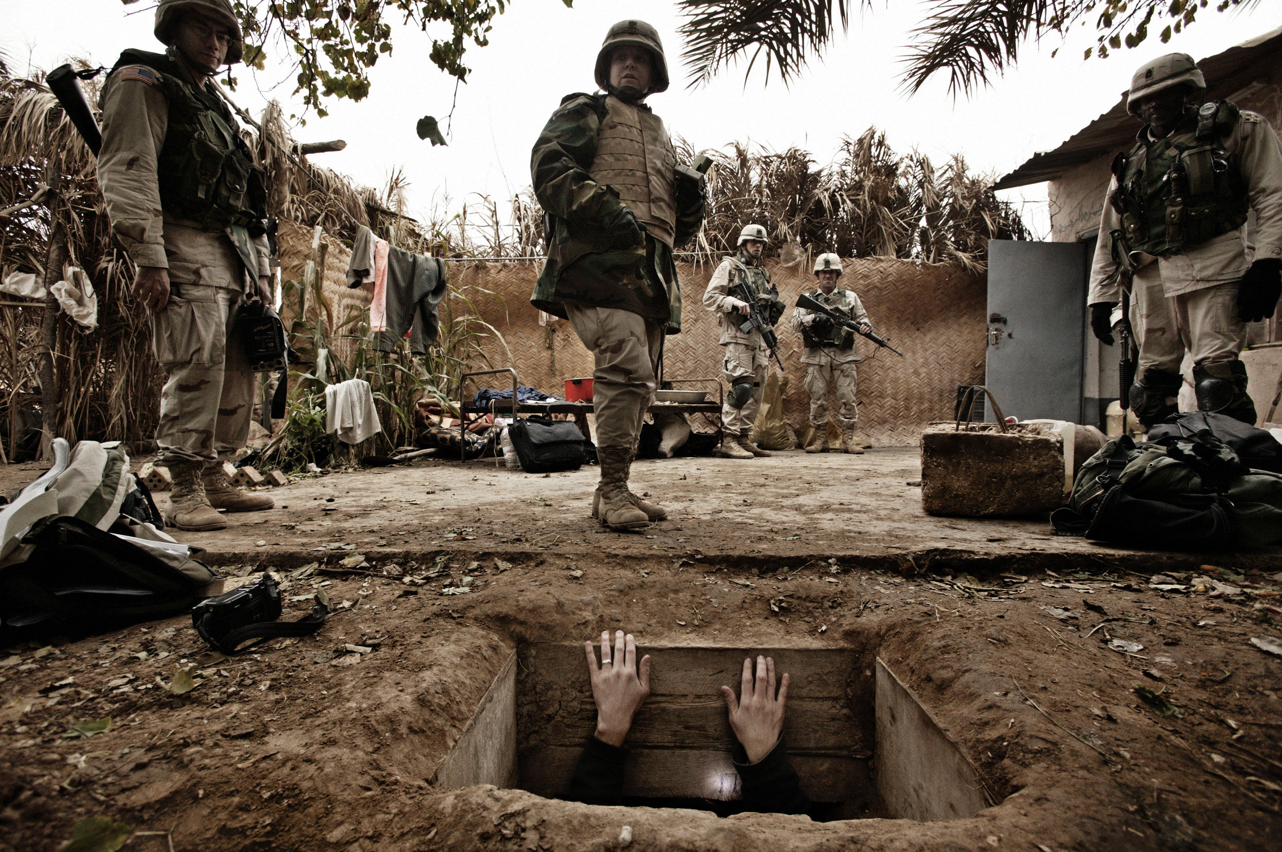 A jounalist climbs out  of the hole where toppled dictator Saddam Hussein was captured in Ad Dawr,  Iraq, near his hometown of Tikrit, Dec. 15, 2003.