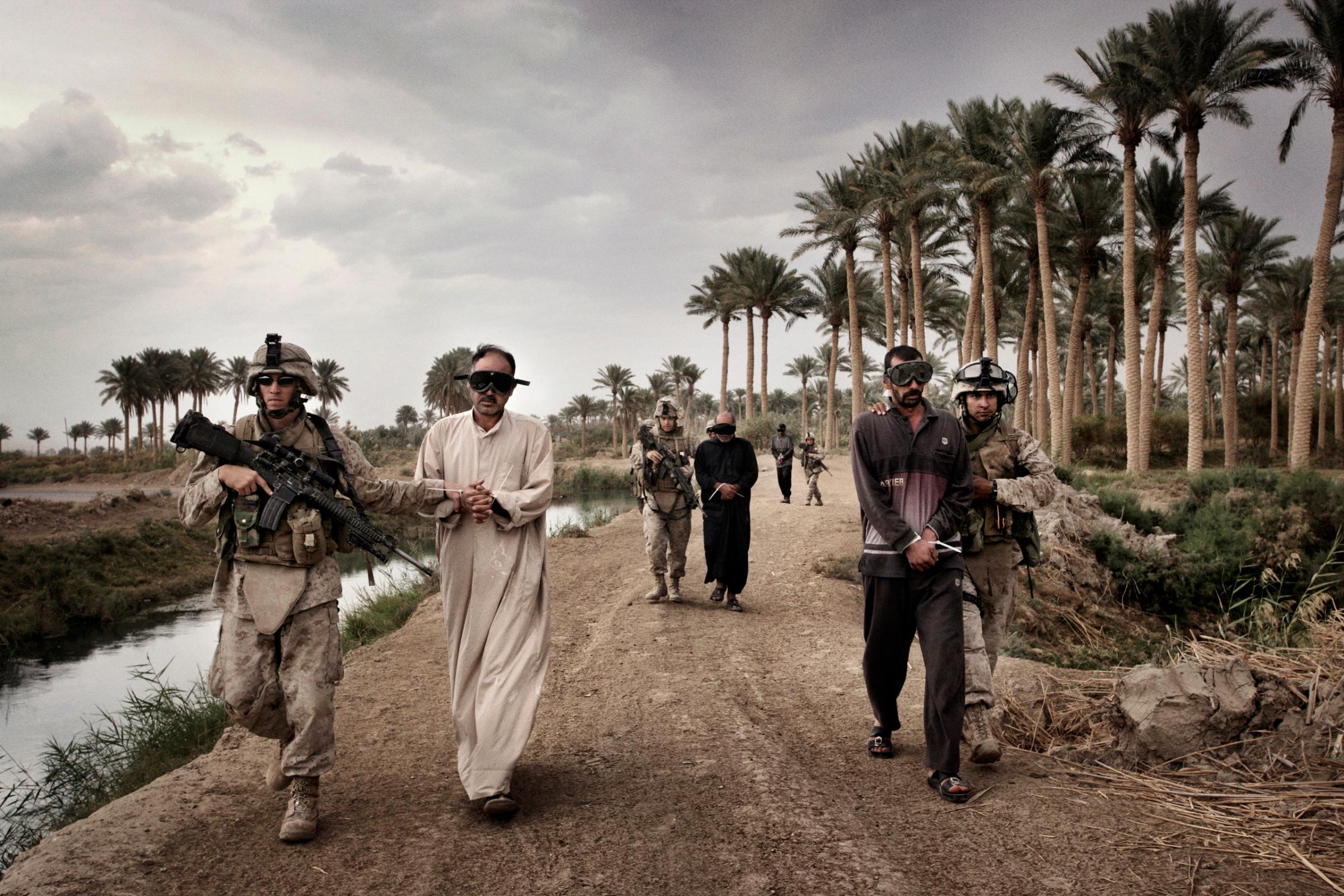 Marines escort suspected insurgents, including Ali Muhammad Said, accused of leading a mortar team in attacking Camp Delta outside al-Karmah, Fallujah, Iraq, Oct. 29, 2005.