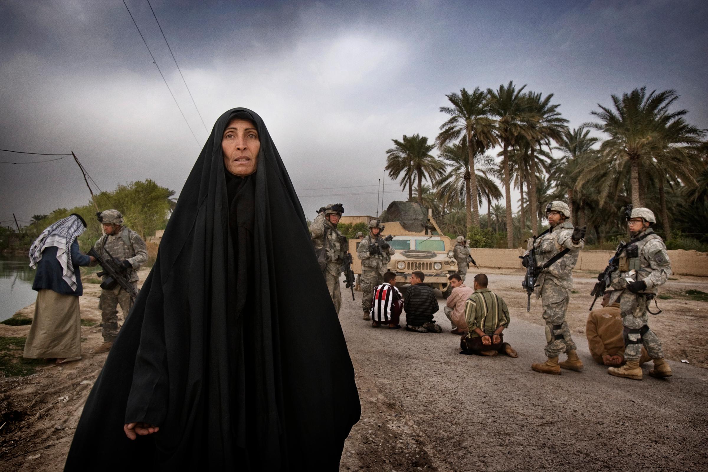 U.S. soldiers from A Troop 5th Squadron 73rd Cavalry detain suspected insurgent sympathizers after killing a militant caught laying a roadside bomb on the outskirts of Baquba. Women from the village begged for the release of the men as U.S. soldiers led them away, Zurah, Iraq, March 15, 2007.