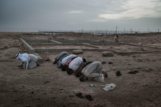 Men pray outside a camp for internally displaced people (IDP's) near the Iraqi town of Makhmour, May 17, 2016. The United Nations said in April that as many as 30,000 people could be forced to flee instability in the Makhmour area, as the Iraqi military pursues an offensive against Islamic State militants in the district.