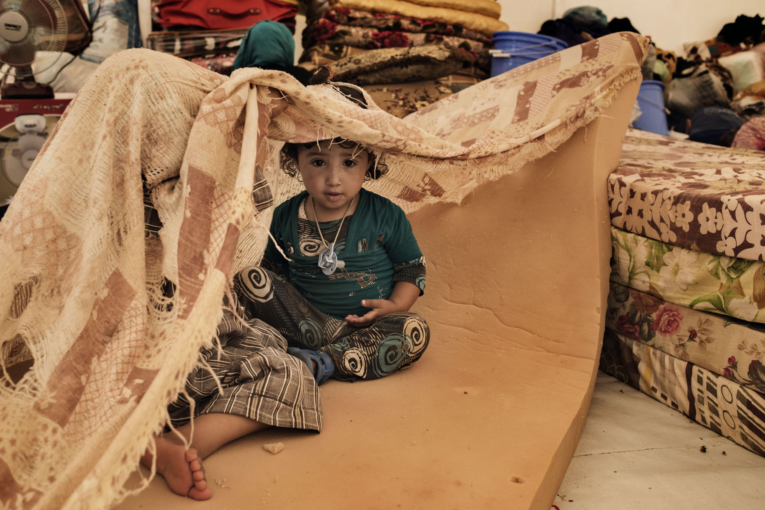 A displaced child sits in a tent in a camp near the Iraqi town of Makhmour, northern Iraq, May 2016.  The United Nations said in April that as many as 30,000 people could be forced to flee  instability in the Makhmour area, as the Iraqi military pursues an offensive against Islamic State militants in the district.