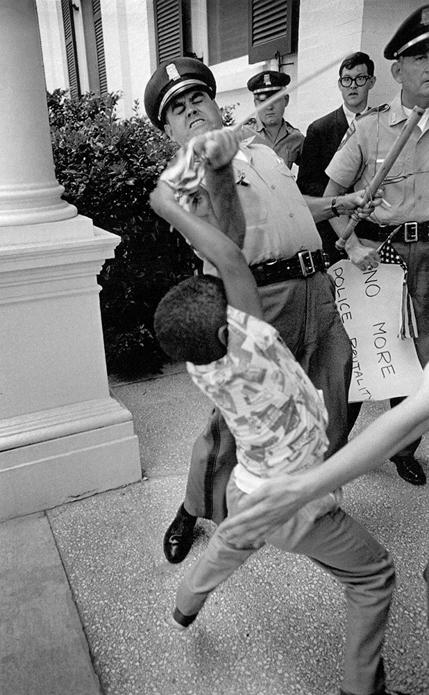 Mississippi Highway patrolmen arrests Anthony Quin, 5, son of Mrs. Aylene Quin during voting rights protest in Jackson Mississippi, 1965.