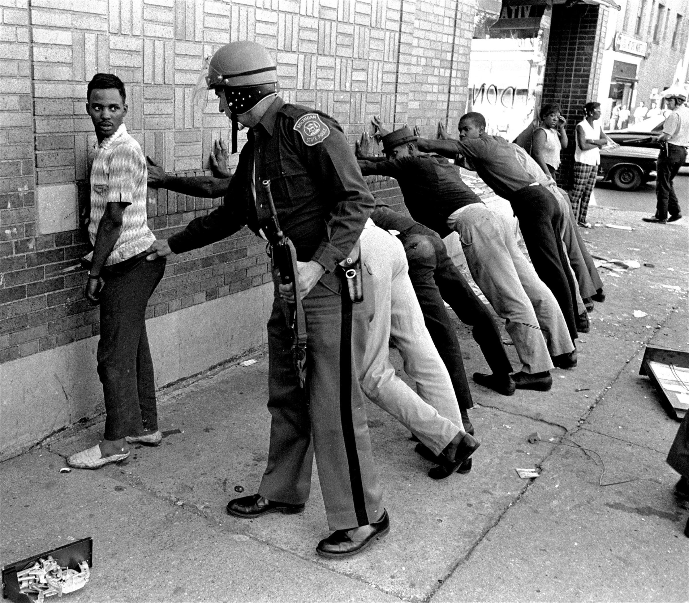 A Michigan State policeman searches a youth on Detroit's 12th Street, July 24, 1967, where looting was still in progress.