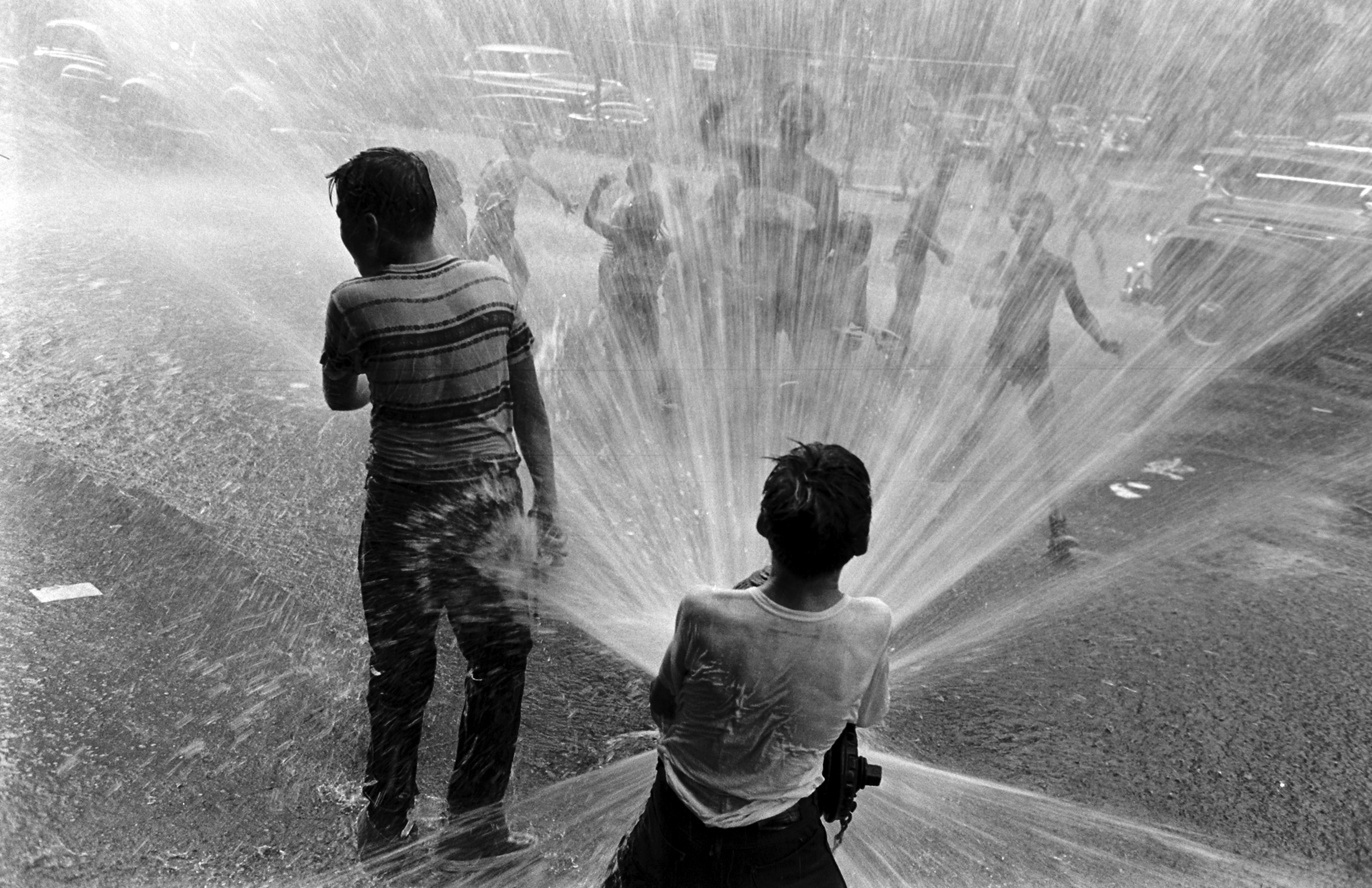 Children playing in water during a heat wave in New York City, 1953.