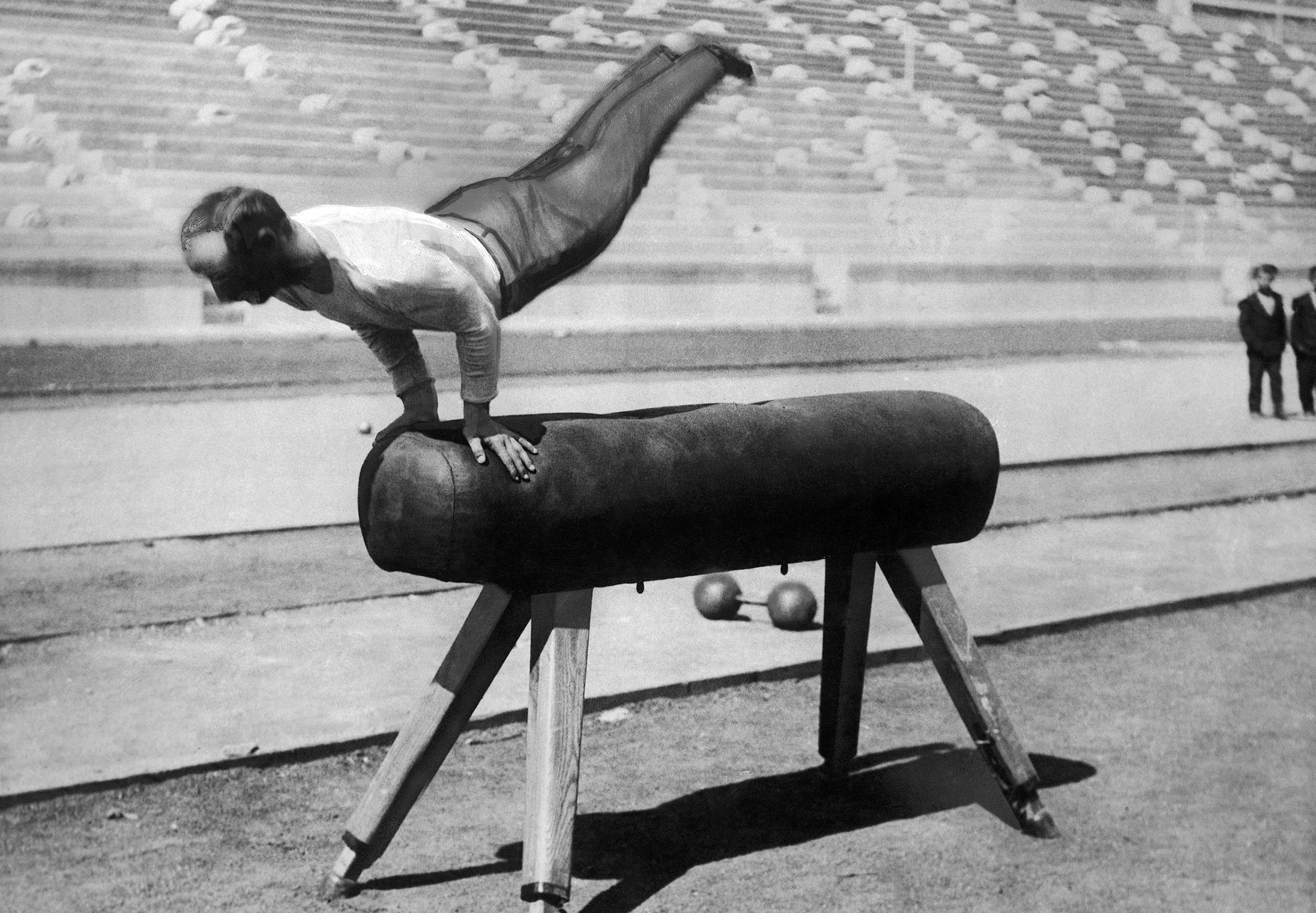 Member of the German gymnastics team Karl Schumann (also Carl Schuhmann), shows his gold medal winning routine at the vaulting horse at the first modern International Summer Olympic Games held at the Panathinaiko Stadium on April 9, 1896 in Athens, Greece.
