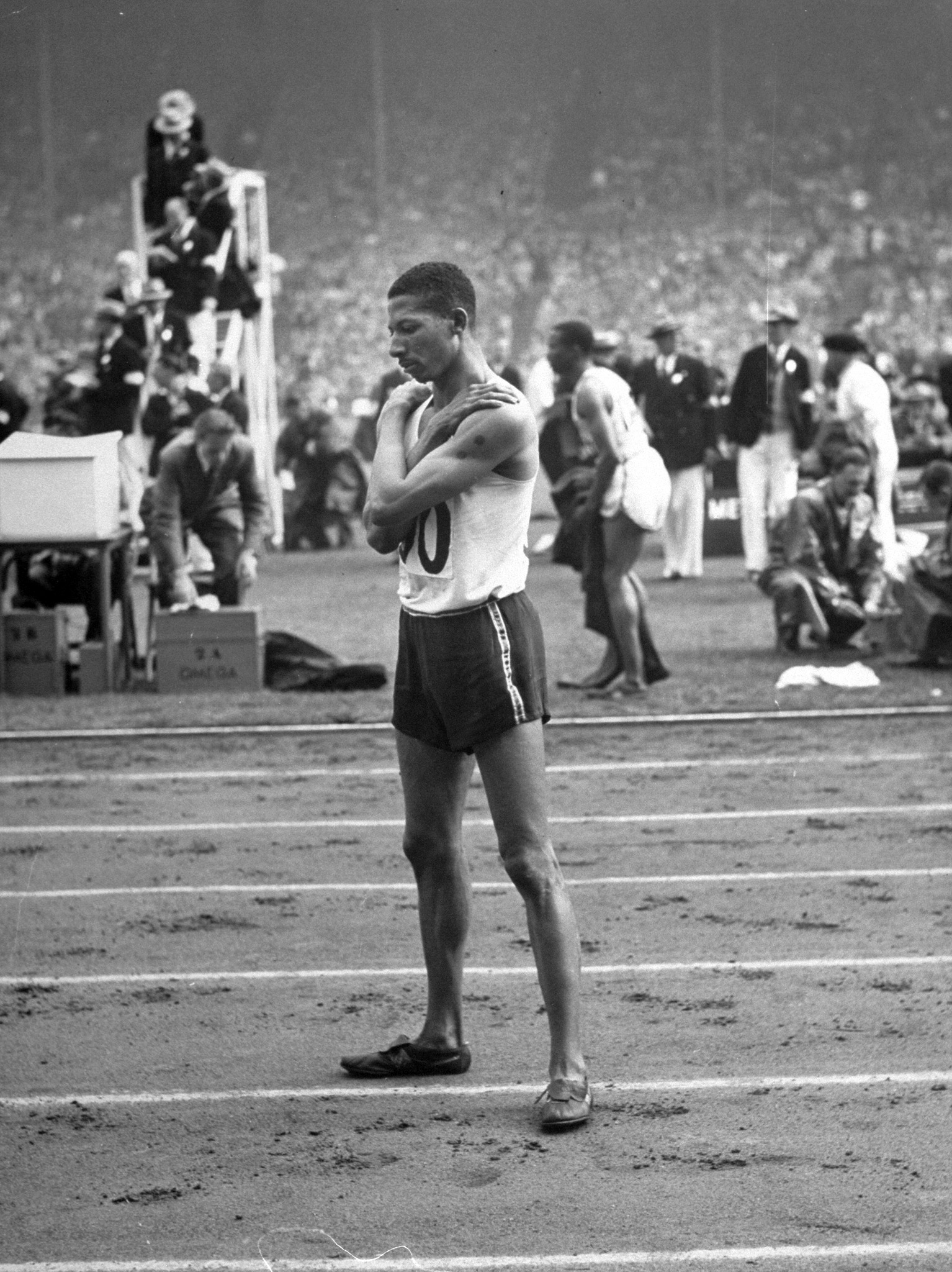 Jamaican athlete Herb McKenley standing on a track at the 1948 summer Olympics in London.