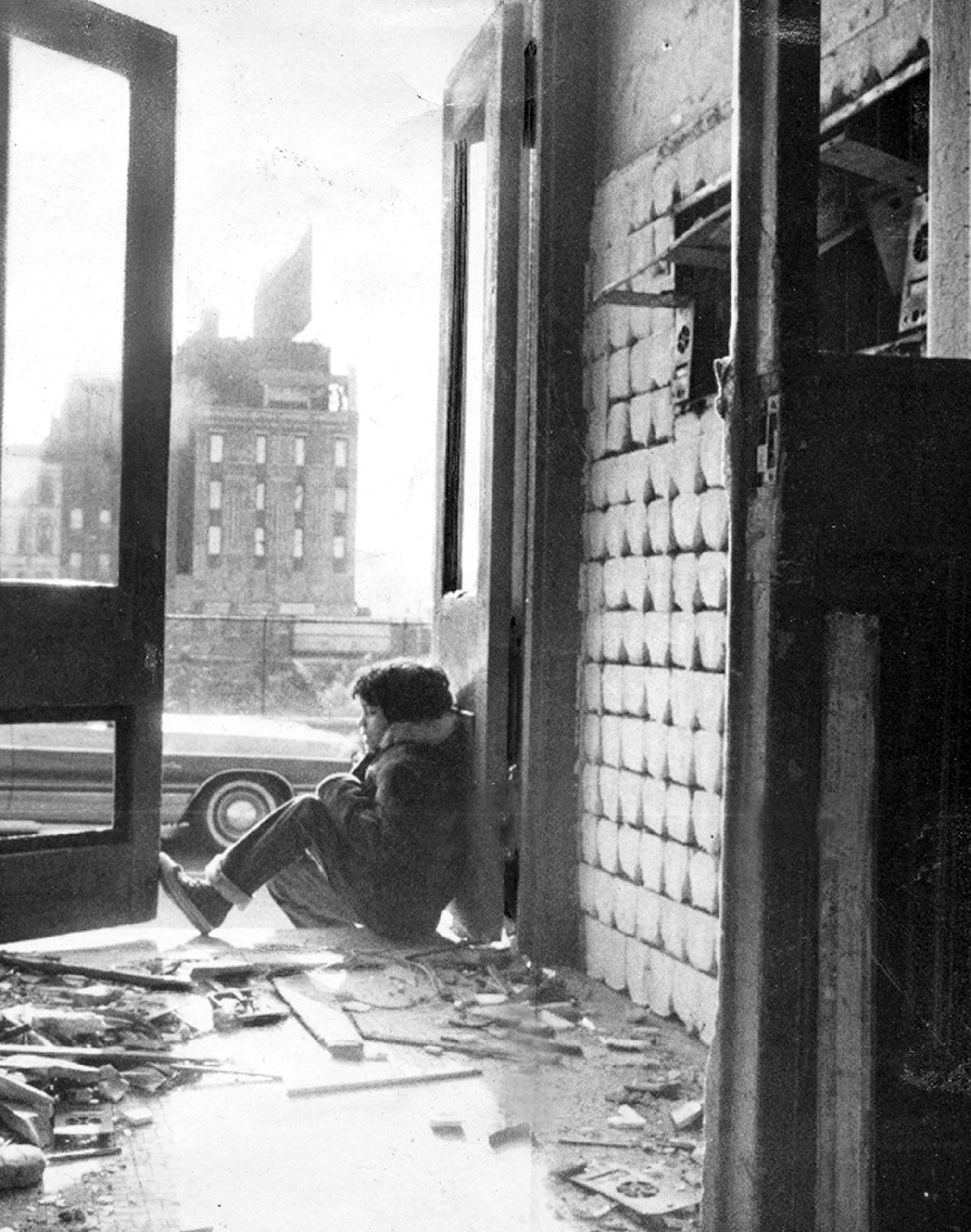 Child sits in doorway of rundown building at 135th St and Willis Ave. in the South Bronx, 1976.