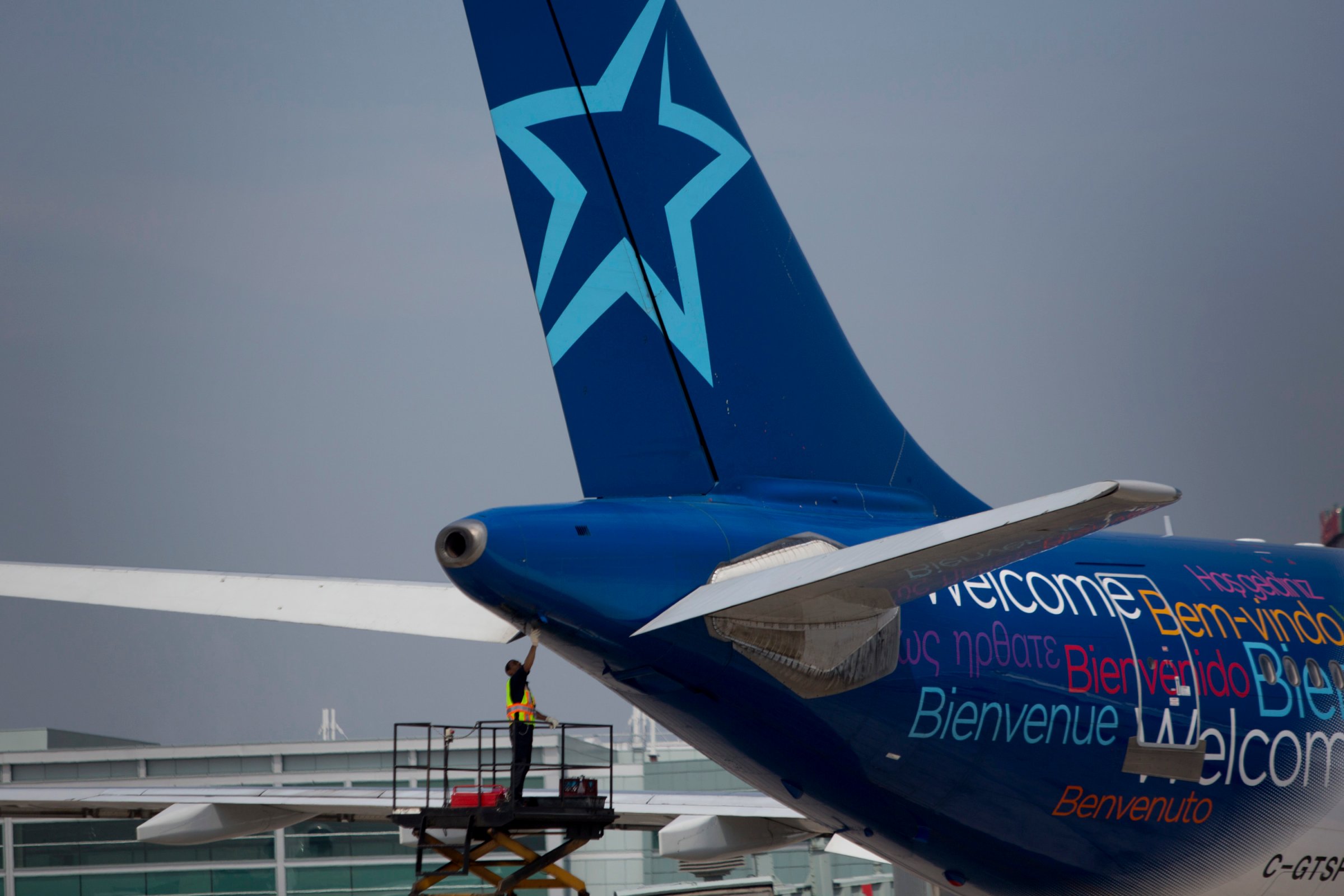 A worker inspects the rear of an Air Transat aircraft at Toronto Pearson International Airport in Toronto, Ontario, Canada, on July 3, 2013.