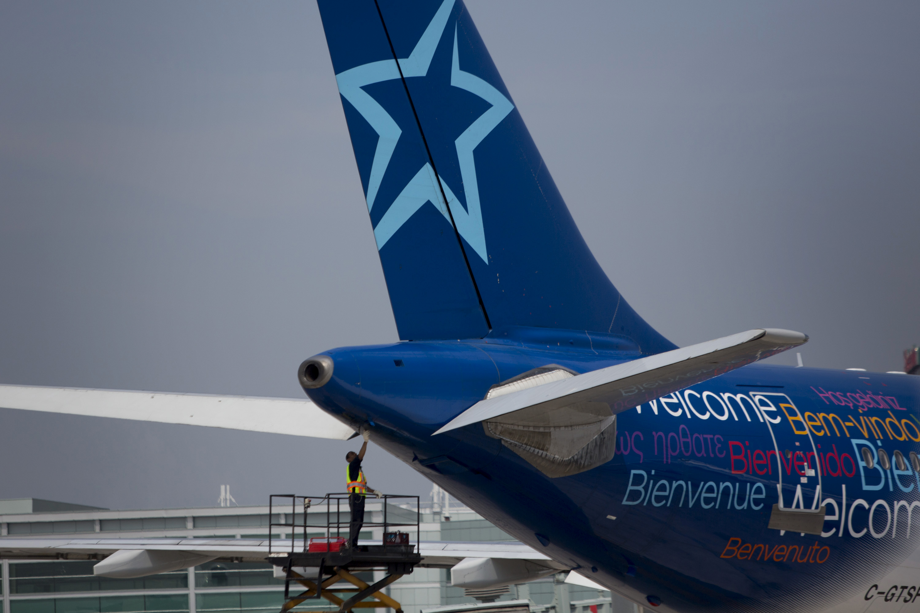 A worker inspects the rear of an Air Transat aircraft at Toronto Pearson International Airport in Toronto, Ontario, Canada, on July 3, 2013. (Brent Lewin—Bloomberg/Getty Images)