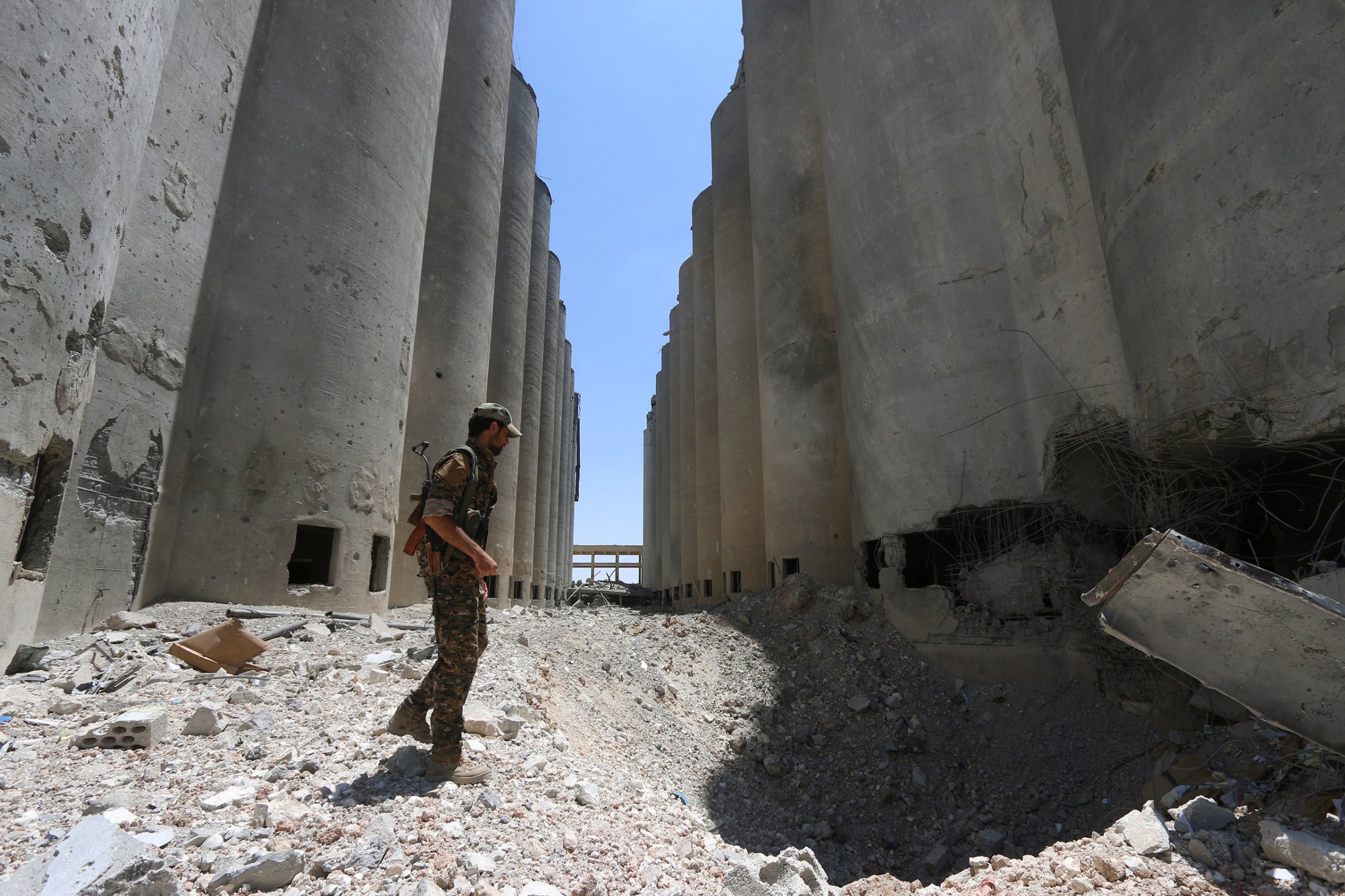 A Syria Democratic Forces (SDF) fighter walks in the silos and mills of Manbij after the SDF took control of it, in Aleppo Governorate, Syria on July 1, 2016.