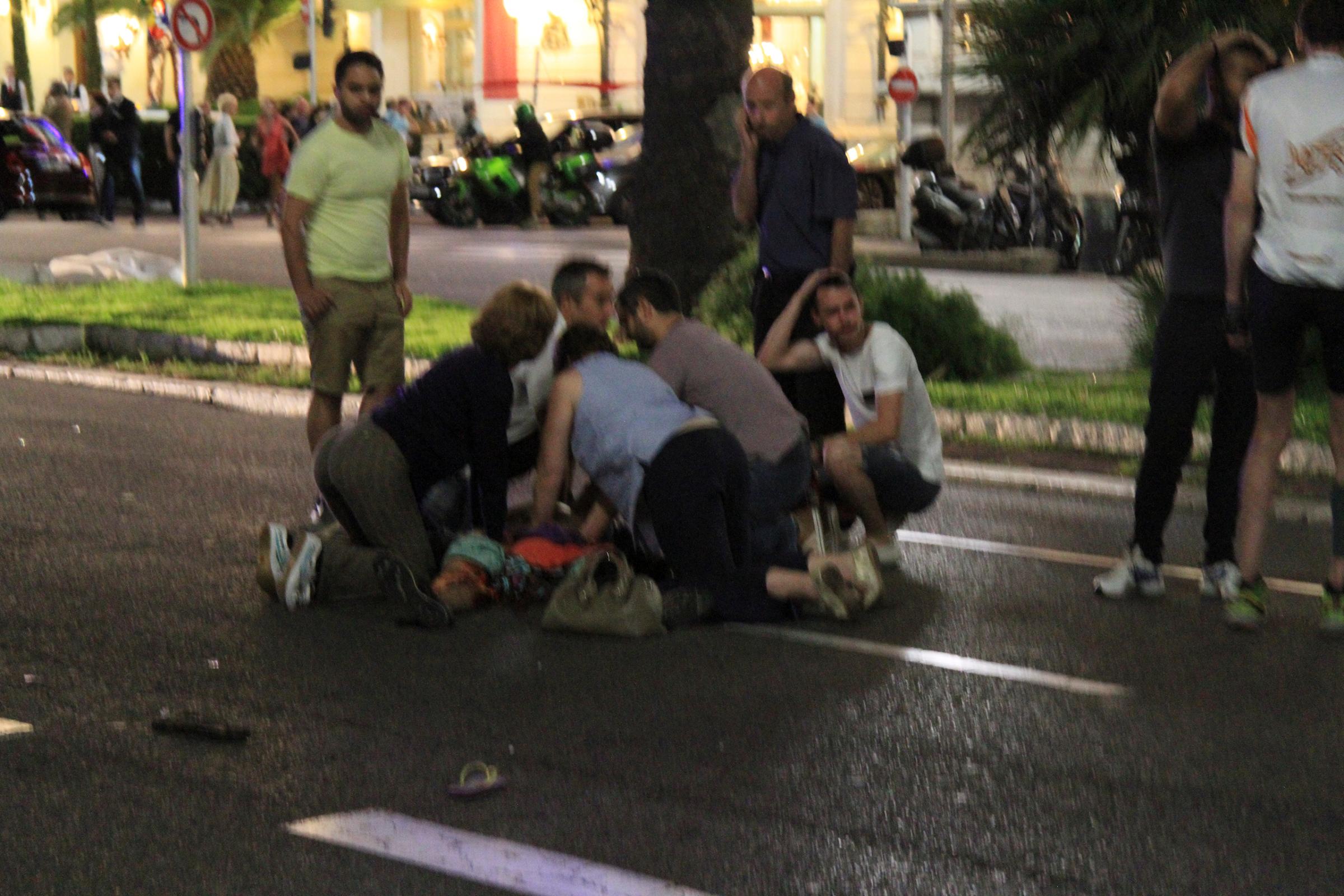 Bystanders tend to victims after a terrorist attack in Nice, France, that left 77 dead and many more injured, July 14, 2016