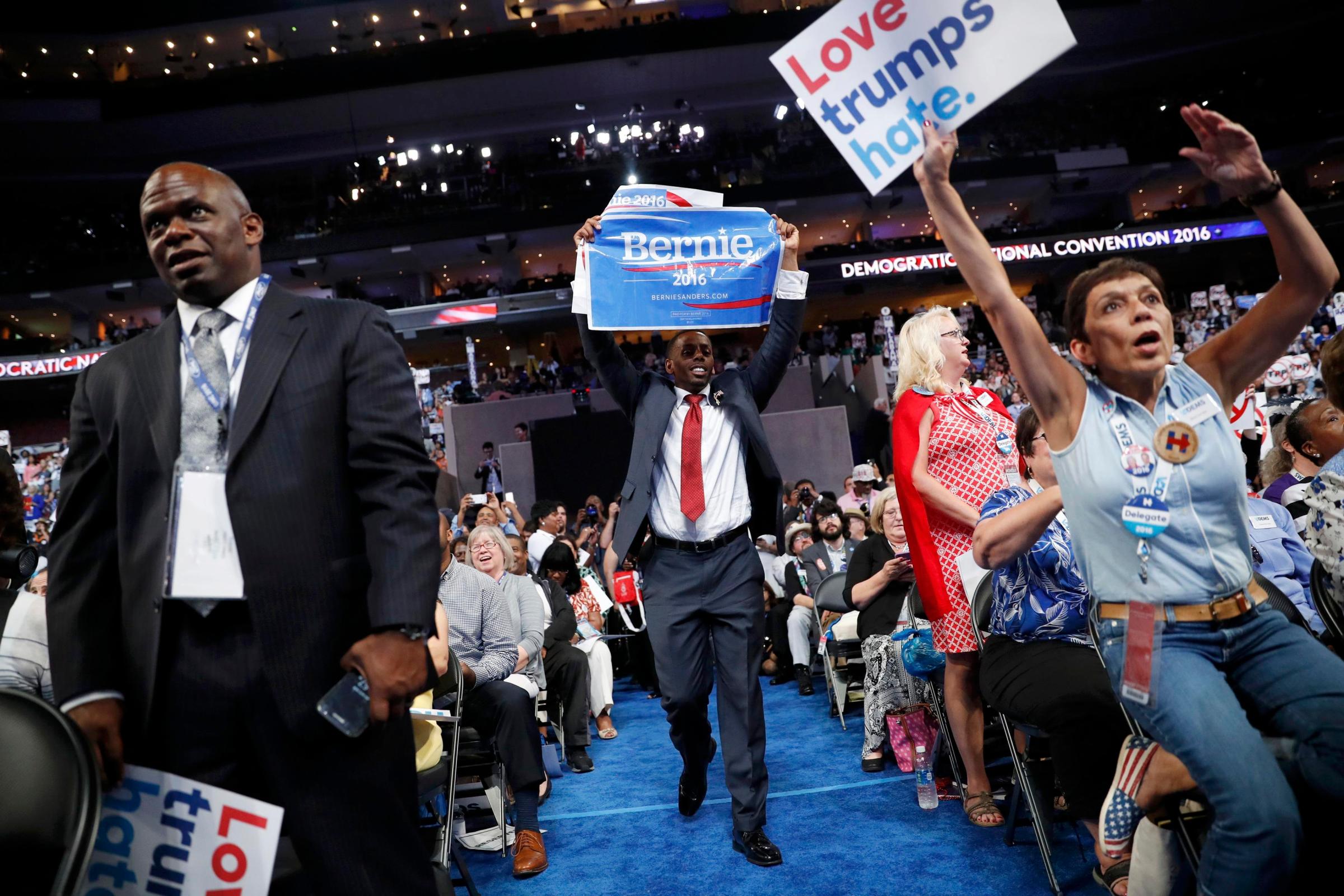 A supporter of former Democratic presidential candidate Bernie Sanders approaches the podium with a Sanders campaign sign during the report of the Rules Committee at the Democratic National Convention in Philadelphia on July 25, 2016.