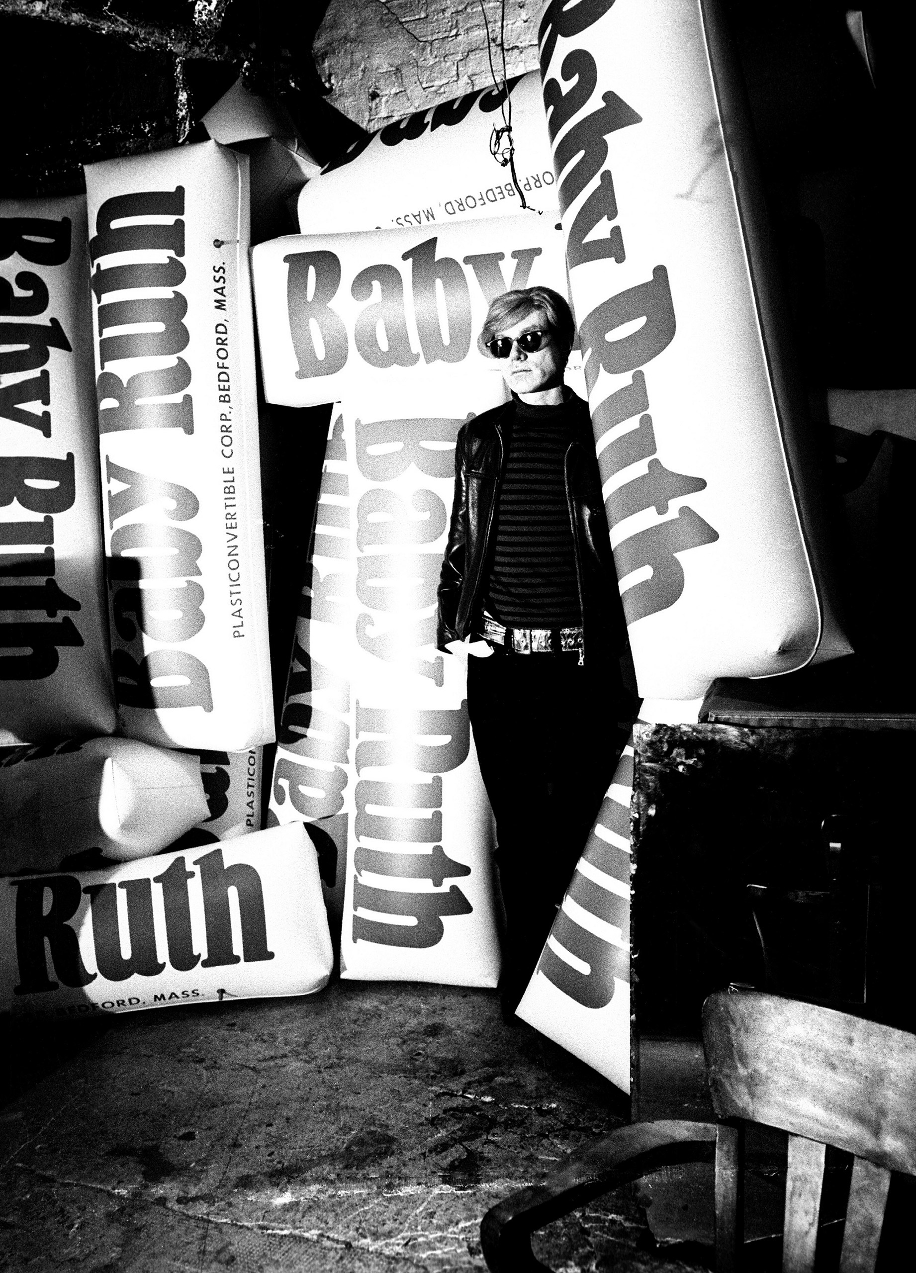 Andy Warhol standing with blow up Baby Ruth bars at the Factory in New York, 1967.