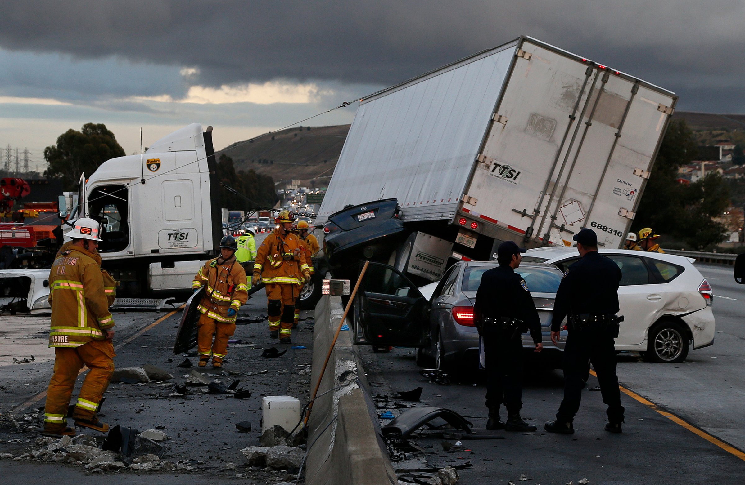 Firefighters and rescue personnel are on scene after a big rig crashed through the center divider crushing a car underneath and causing four other vehicles to collide on the rain slicked 60 freeway near the Garfield Exit in Monterey Park, Calif. on January 5, 2016.