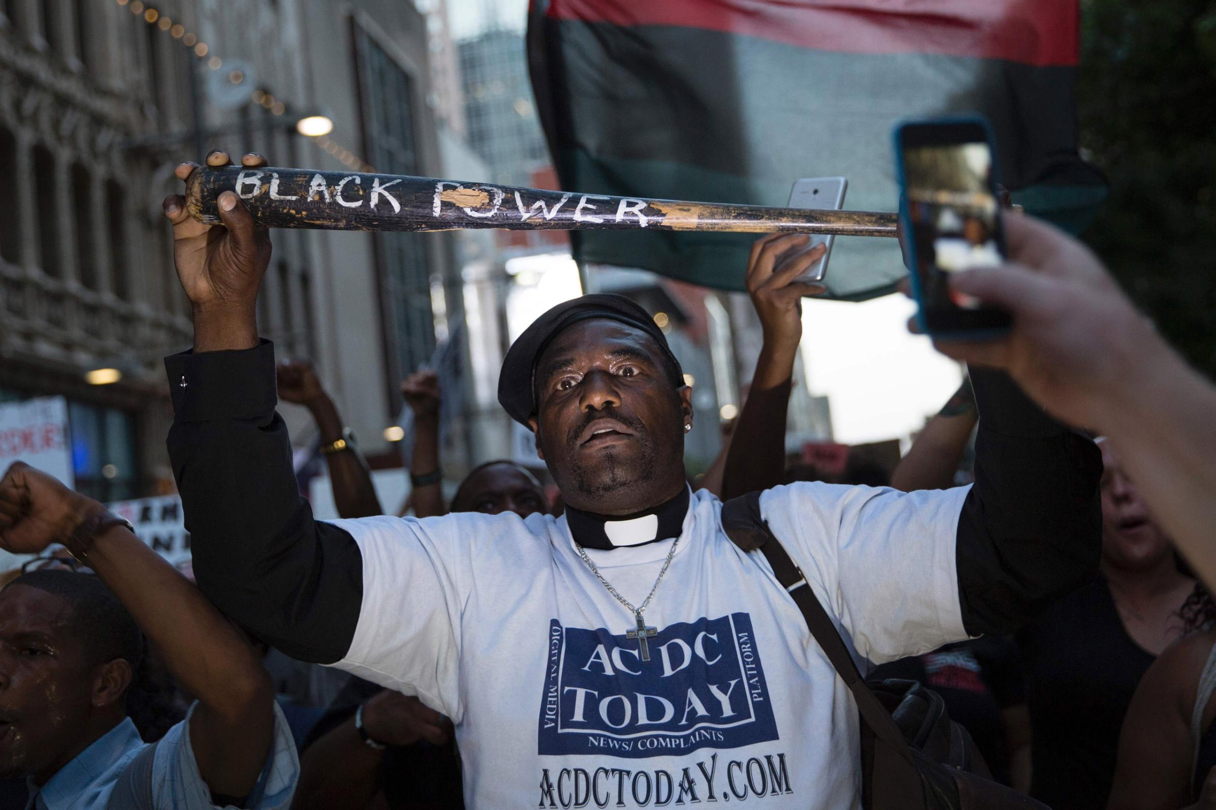 TOPSHOT-US-CRA man holds a bat reading "Black Power" during a protest in Dallas on July 7, 2016.