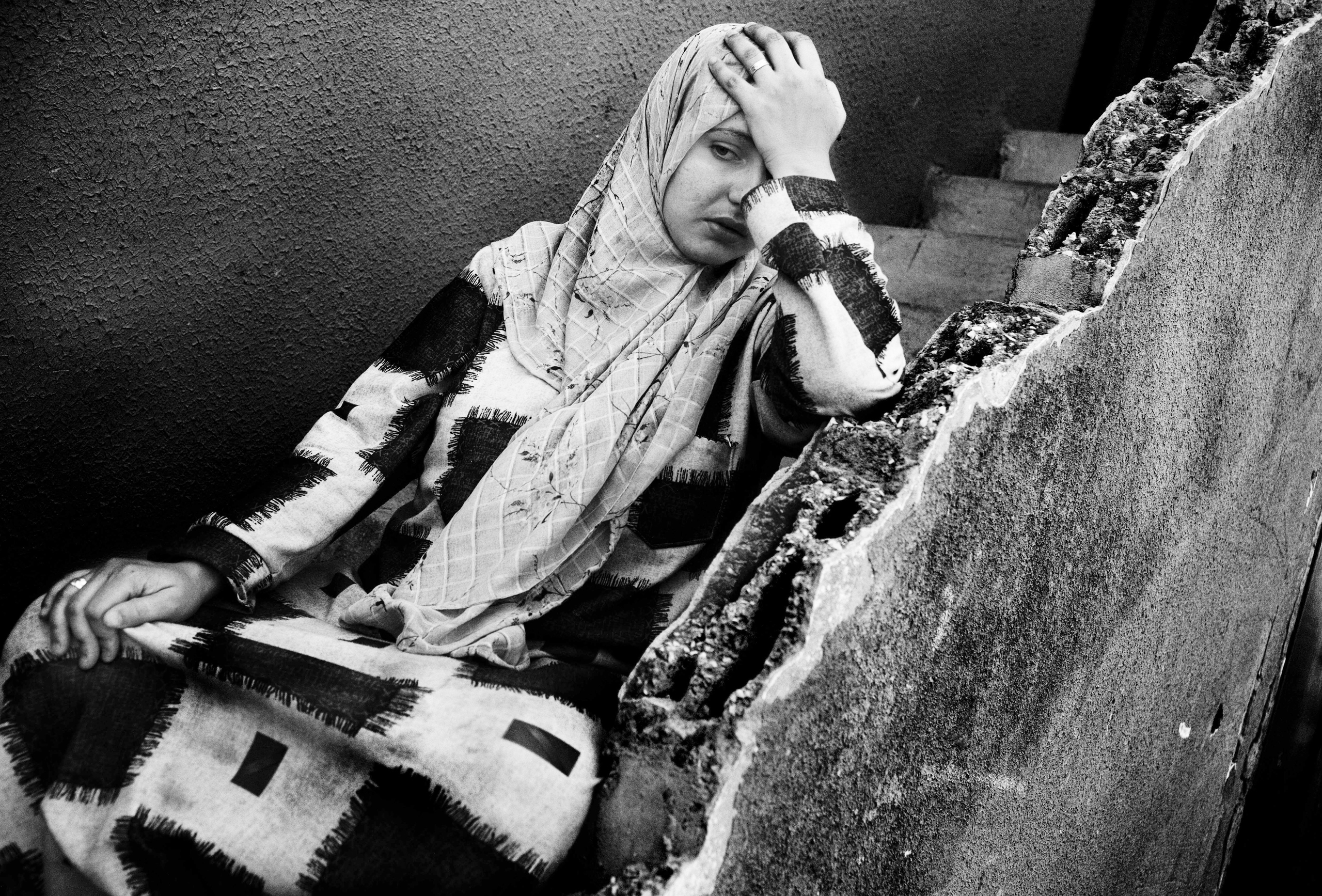 A woman desperate to flee the village is sitting on the stairs of her house. Ramesh, Lebanon, July 2006. (Davide Monteleone)