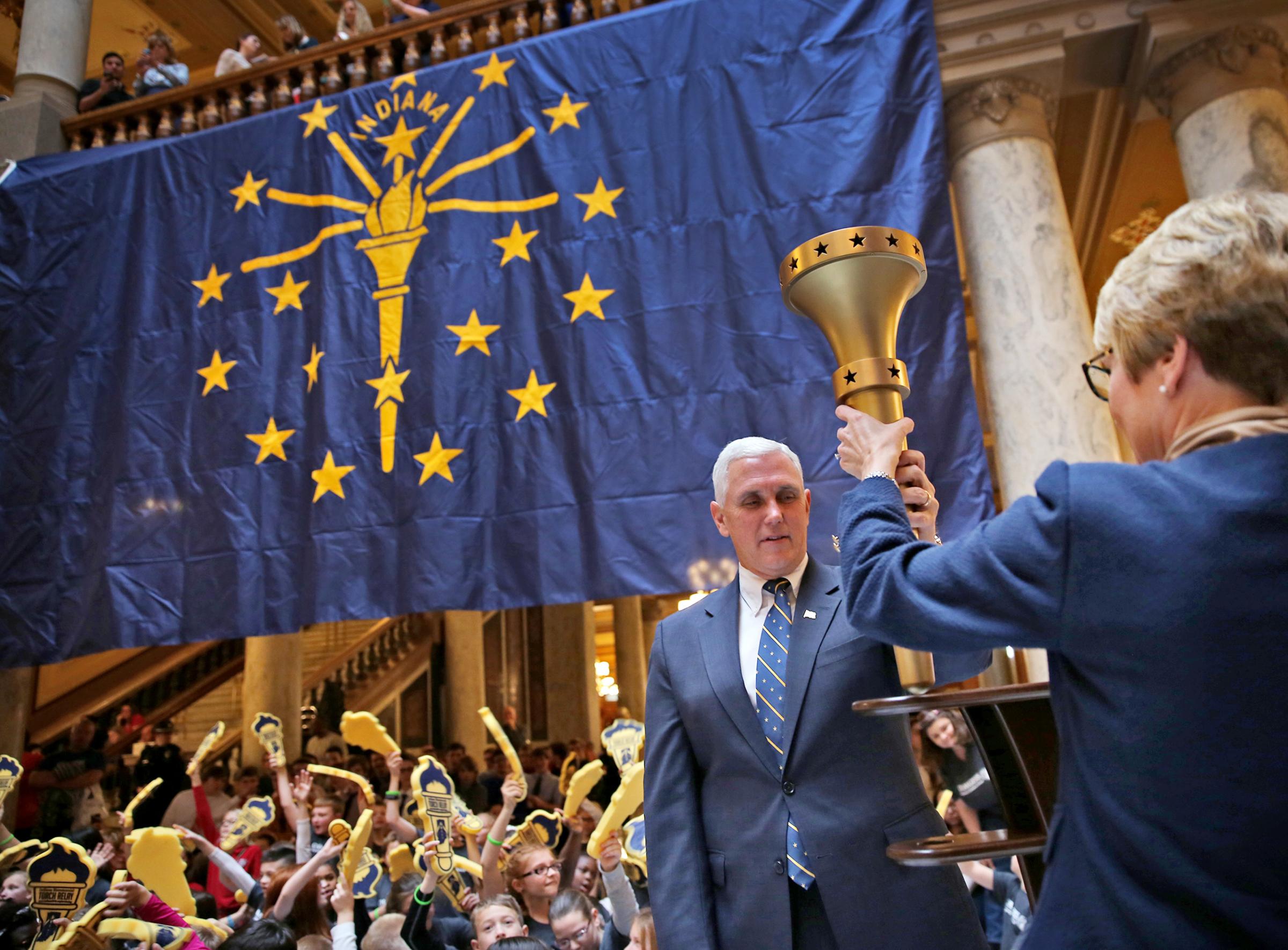 Ind. Gov. Mike Pence and Lt. Goc. Sue Ellspermann unveil the Indiana Bicentennial Torch during a Statehouse event in Indianapolis on Dec. 11, 2015.