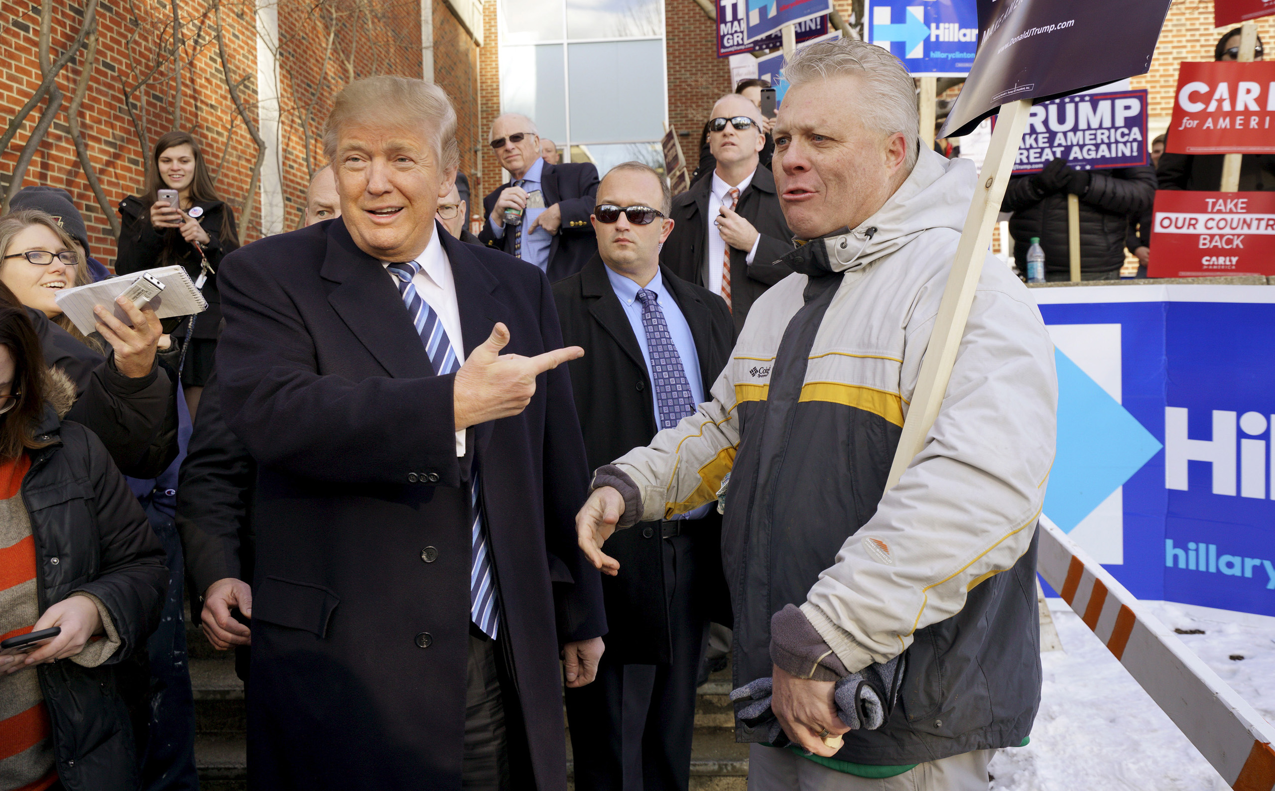 Republican presidential candidate Donald Trump points at a supporter at a polling place for the presidential primary in Manchester, N.H. on Feb. 9, 2016.