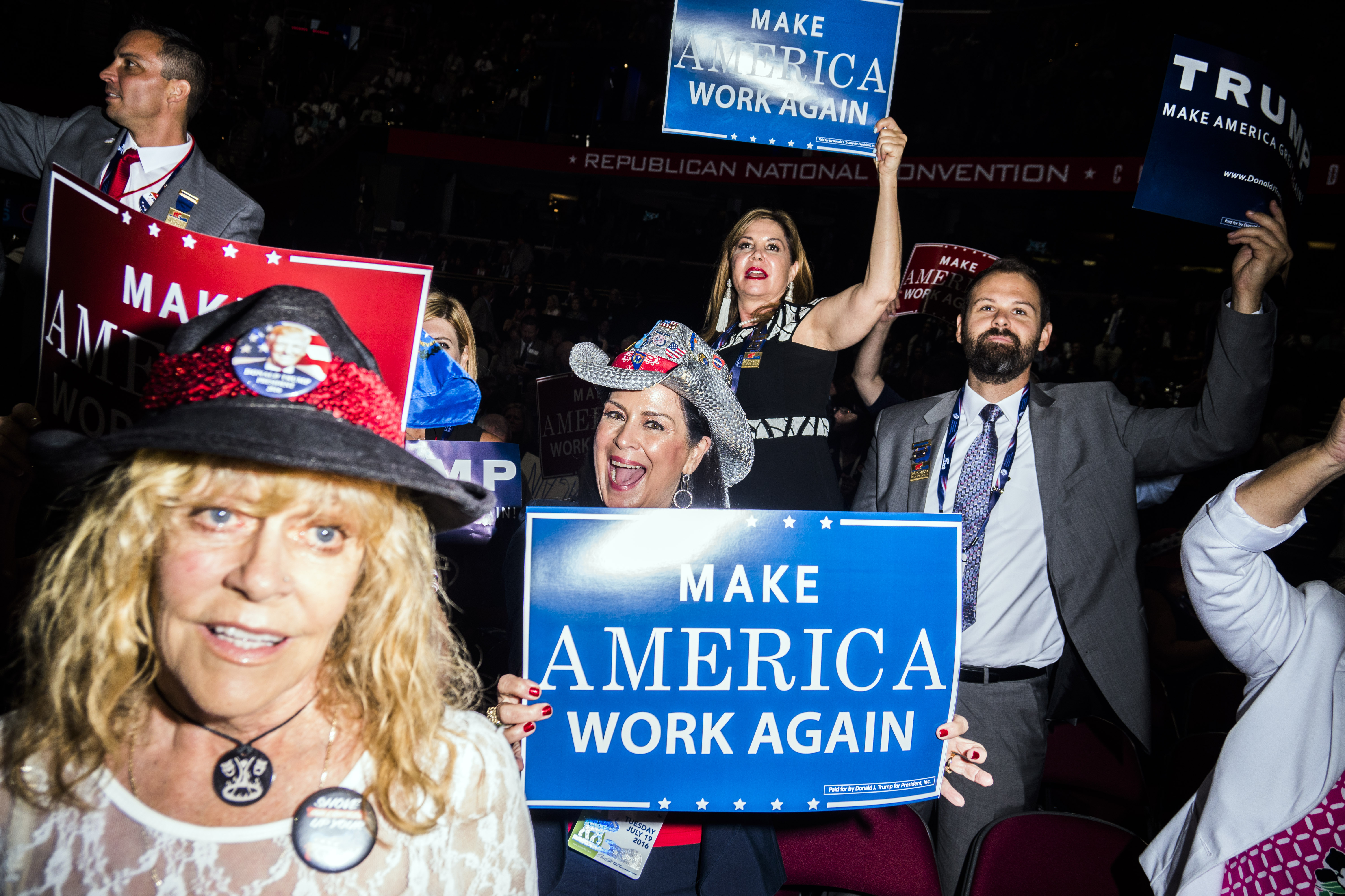 Attendees hold signs at the Republican National Convention in Cleveland on Tuesday, July 19, 2016.
