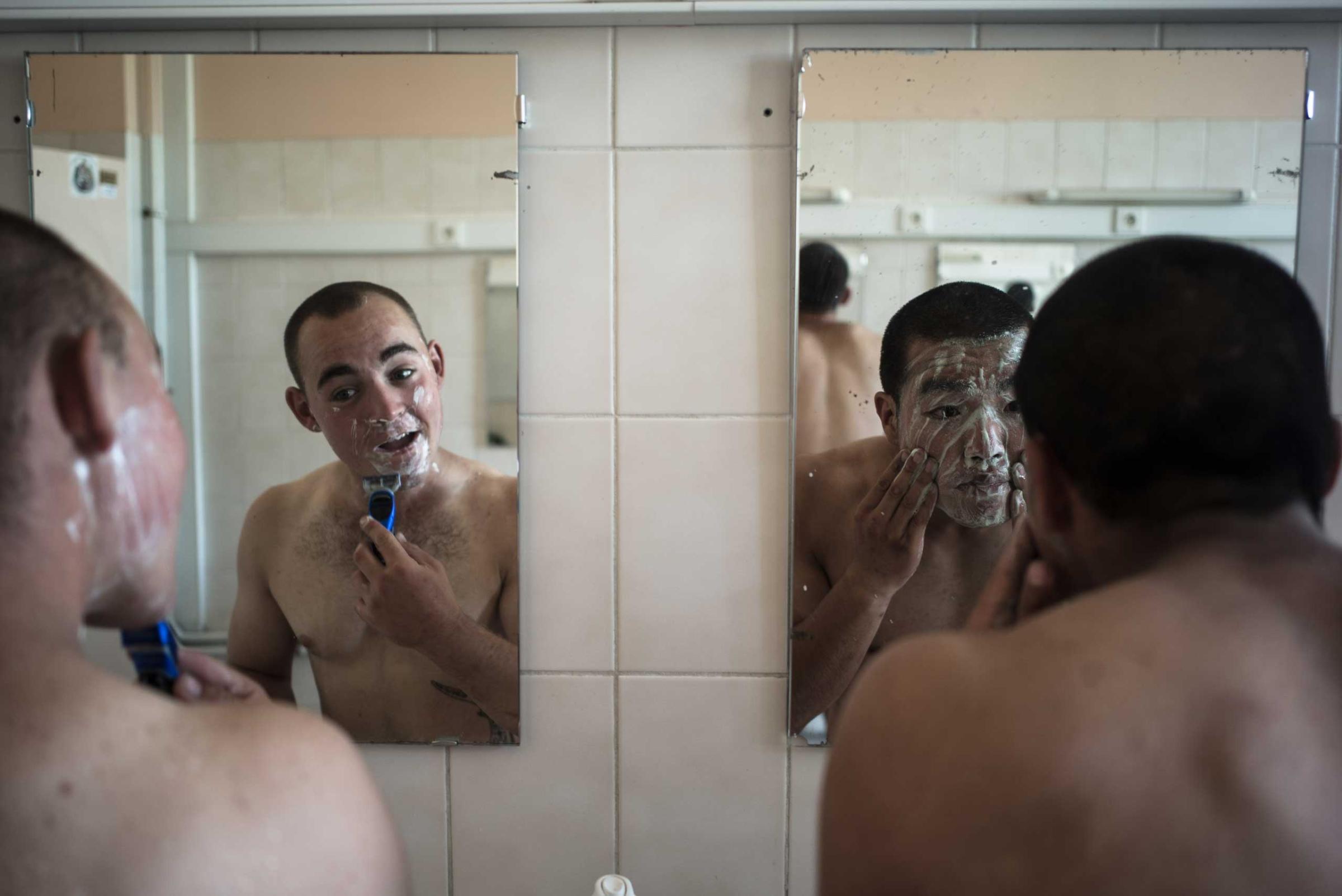 Two members of the French Foreign Legion shave. Nimes, France. Aug. 7, 2015